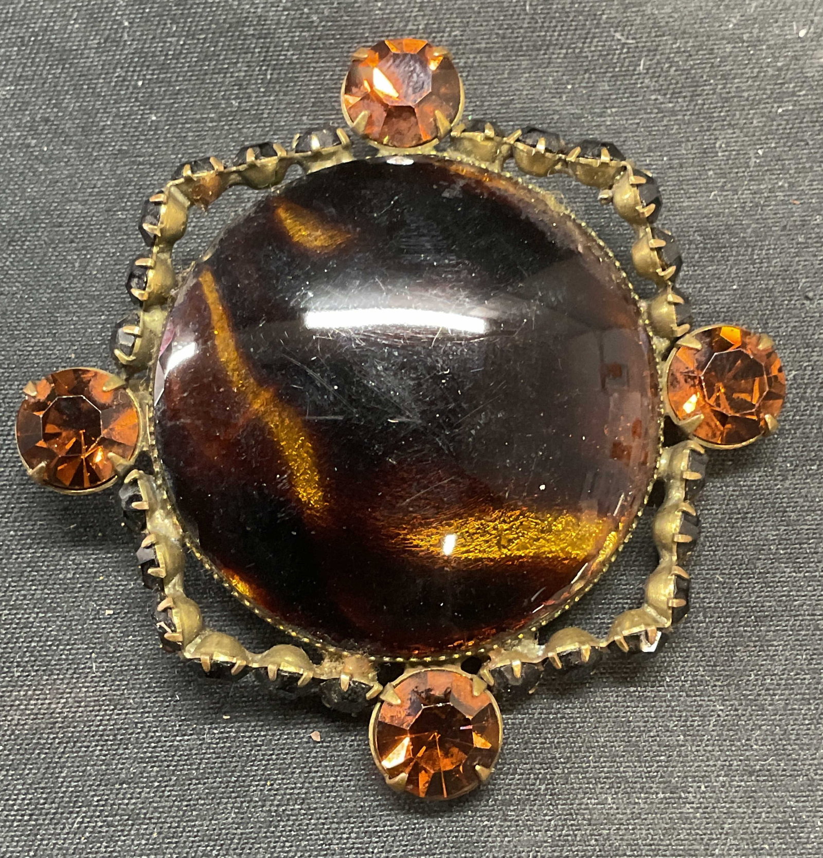 Roger Van S Amber Tone Crystal Brooch: Roger Van S amber tone crystal and marbled acrylic cabochon brooch. Signed on underside. Hinge pin to underside. Measures approx. 1.75 inches wide. Some surface wear including scratching observed. Jew