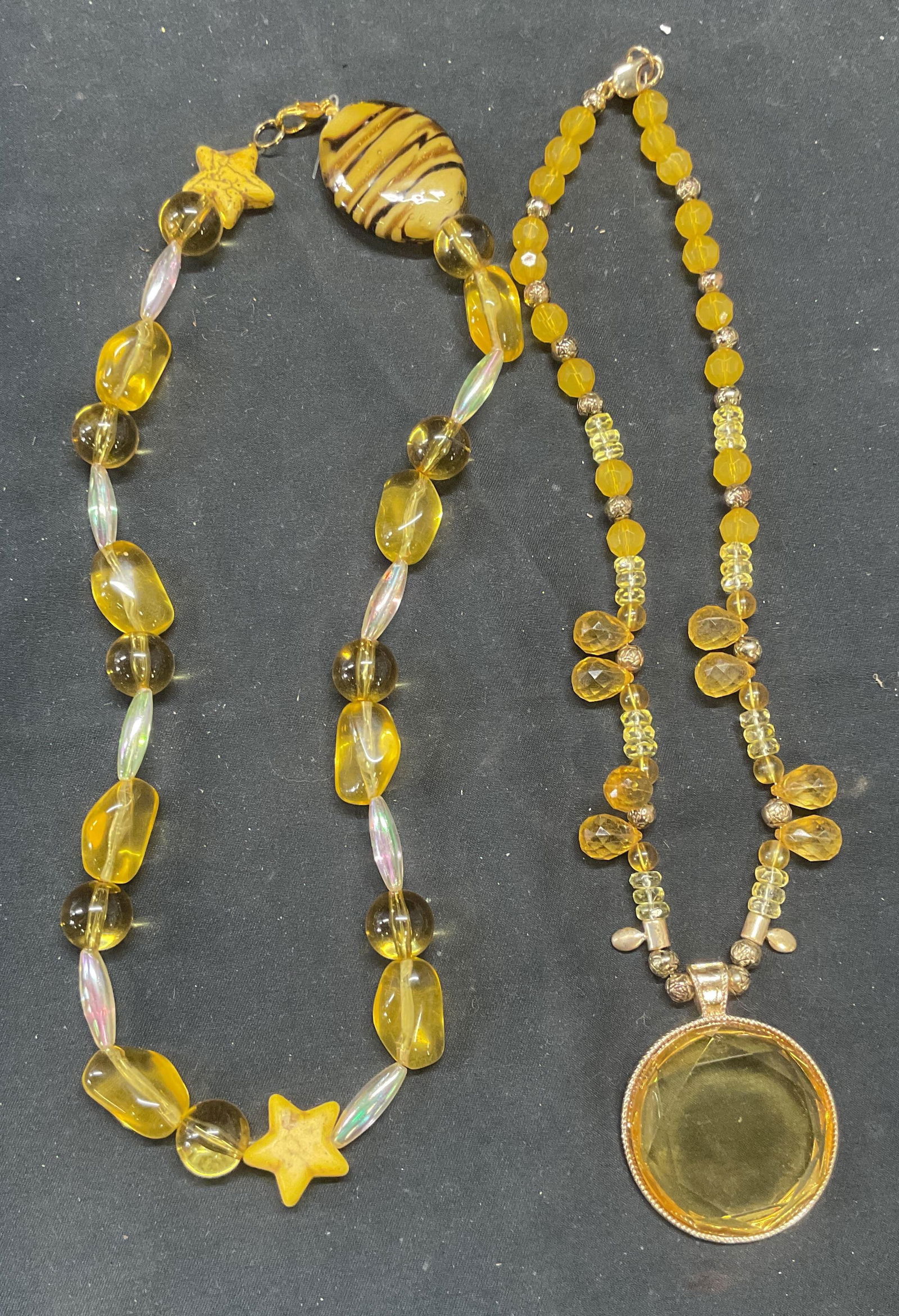 Lot 2 Yellow Art Glass & Crystal Necklaces: Lot of 2 necklaces. Beaded yellow and opalescent necklace with art glass and star motif accents. Drop length approx. 9.5 inches. Yellow beaded crystal necklace with yellow crystal pendant. Drop length