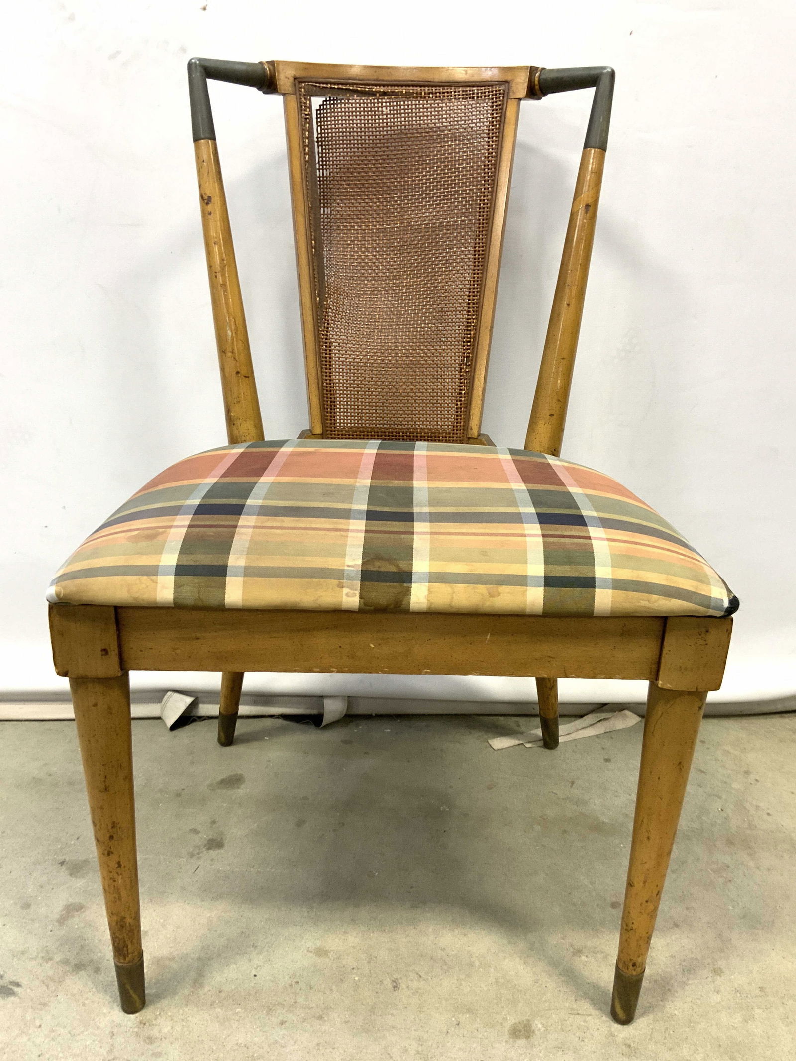 MCM Wood Accent Chair W Caned Backrest: Chair is mid century modern. Piece is tan toned and wooden with tapered legs and metal carp feet. Chair has multi toned patterned upholstered seat. Piece has caned backrest. Chair measures approximate