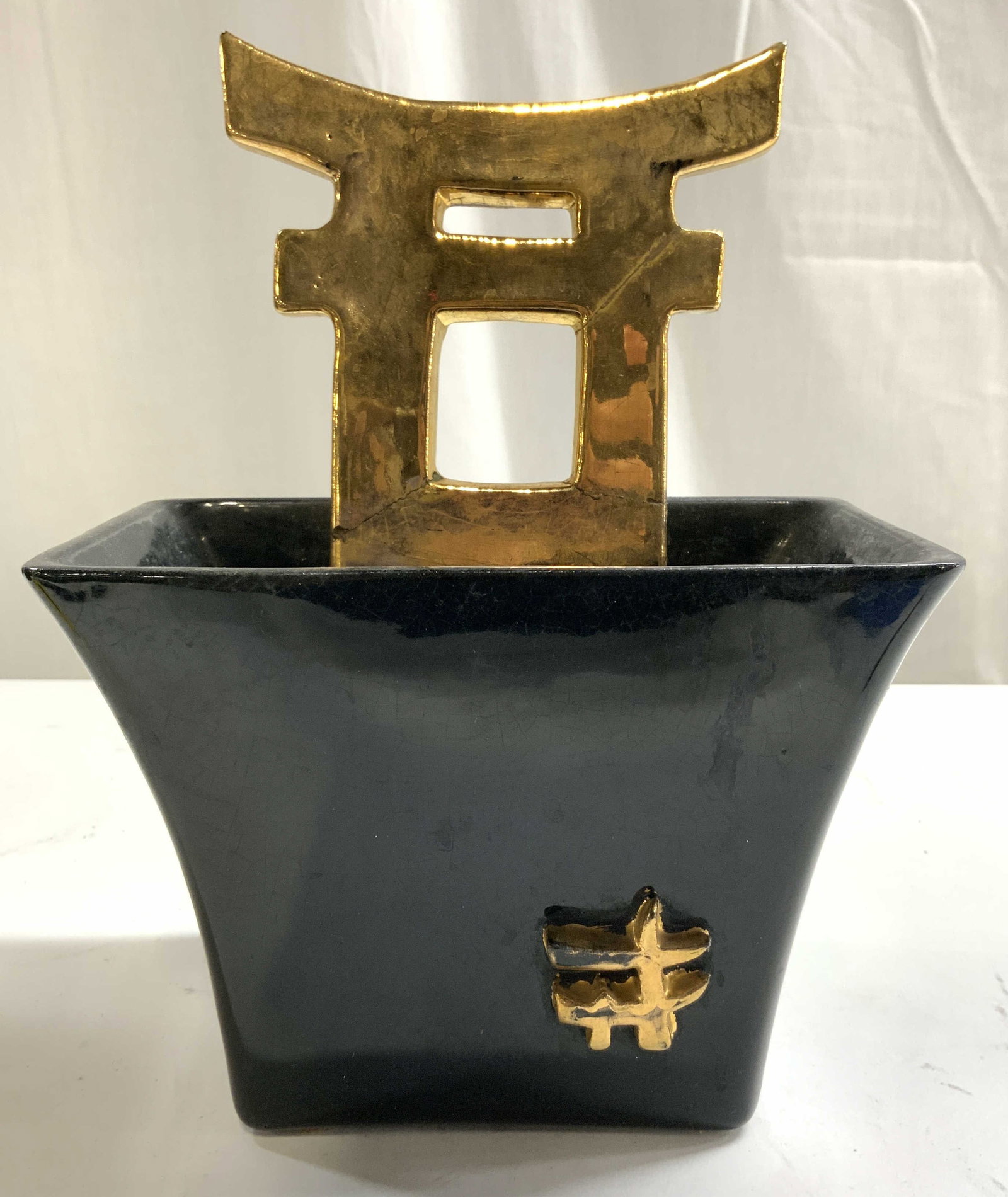 Vntg Black & Gilt Asian Ceramic Wall Planter: Planter is black and gilt. Piece has Shino Gate form. Vessel area expands near top. Piece appears to be ceramic possibly porcelain. Wall planter measures approximately 8.75 inches tall 6.75 inches wid