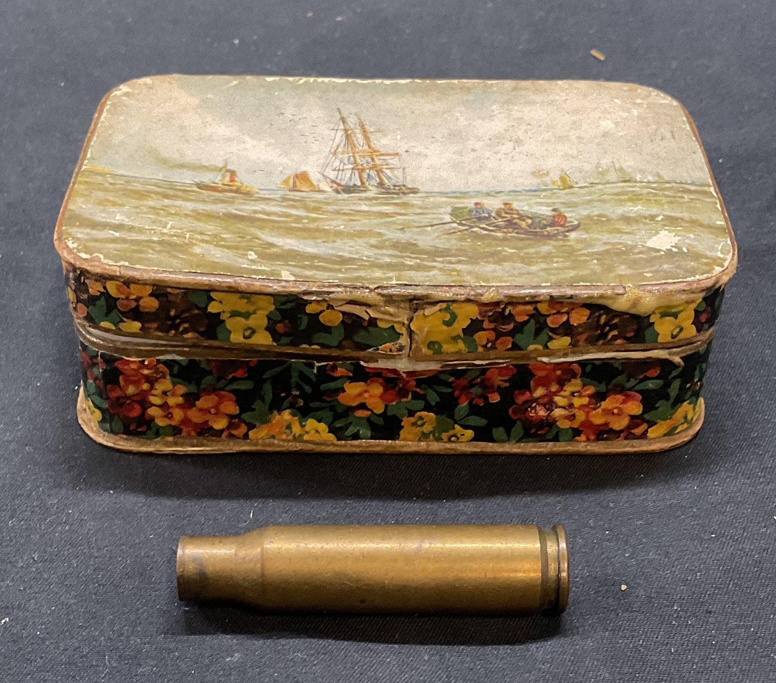 .308 Winchester Brass Rifle Bullet Shell & Box: Winchester brass rifle bullet shell and decorative paper box with ship motif. Bullet shell, stamped WW SUPER 308 WIN. Shell measures approx. 2 inches long. Box measures approx. 3.75 x 2.5 x 1 inches. 