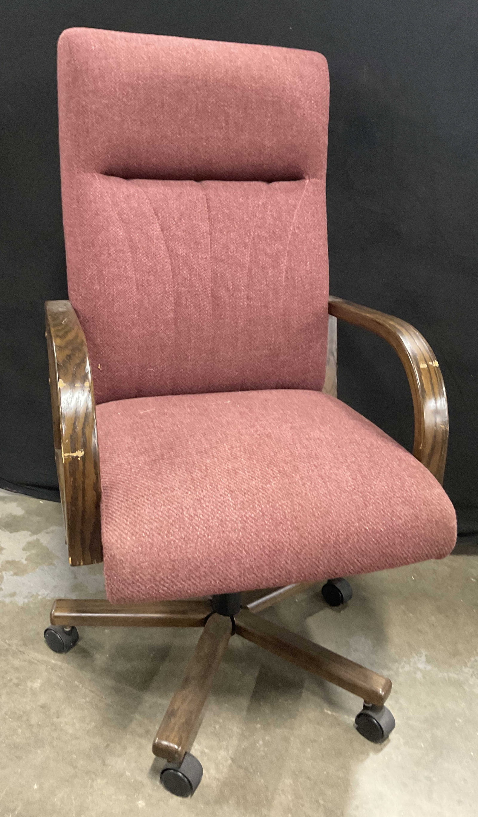 GLOBAL BUSINESS FURNITURE Wheeled Office Chair: A vintage upholstered office chair on wheels. Red hued upholstery. Wooden arms and legs. Measures approx. 43.5H x 24.5W x 22D in. Tag to underside reads GLOBAL BUSINESS FURNITURE. Losses to finish, di