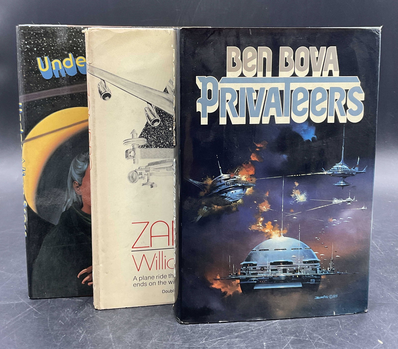 3 Vintage Science Fiction Books, First Editions +: Three vintage science fiction books. Hardcover books with dust covers. Titles include: -Privateers, by Ben Bova, published by Tom Doherty Associates, C. 1985, First printing: October 1985. -ZANDRA by 