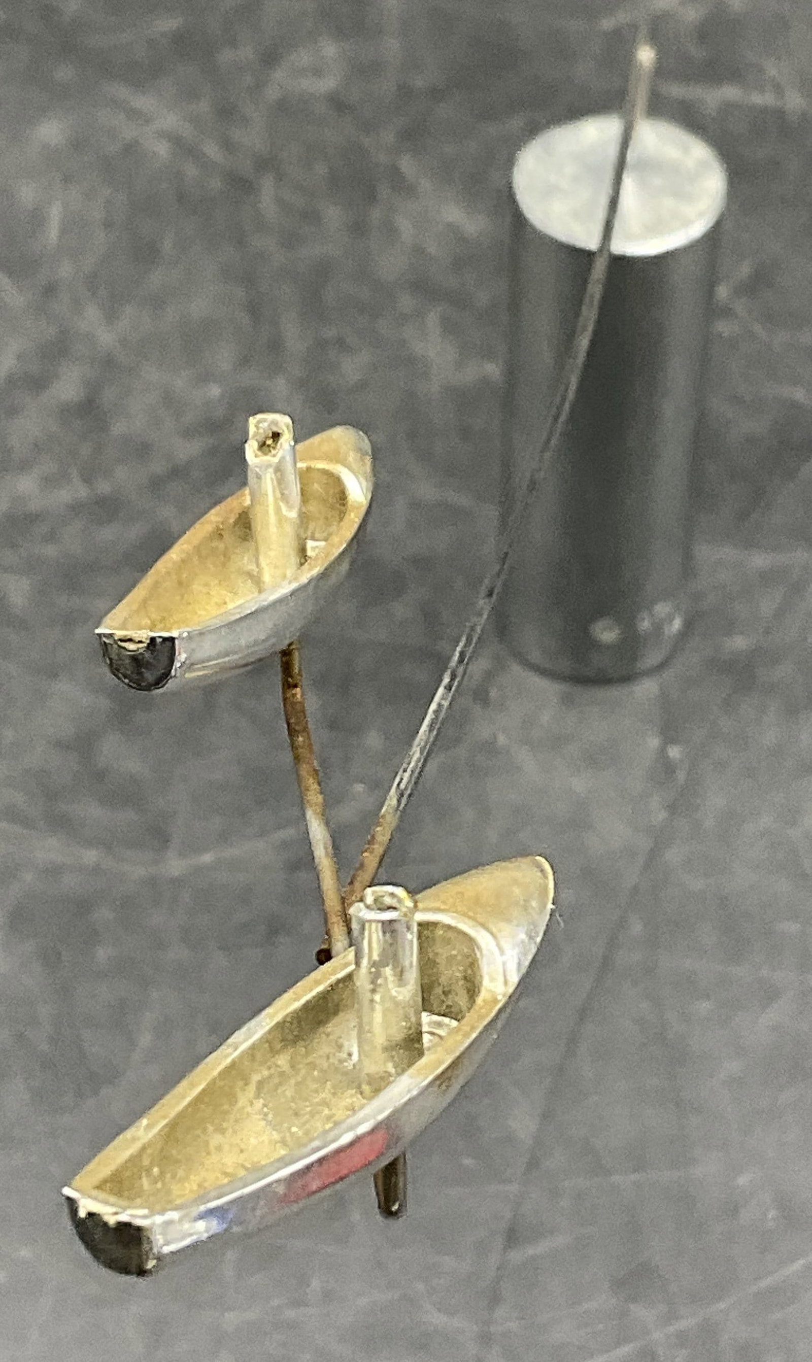 OTAGIRI 1977 Silver Tone Metal Kinetic Sculpture: A vintage silver tone metal tabletop kinetic sculpture. Boats to one side, sphere to the other. Base is cylindrical and measures approx. 2.5H x .75W in. The sphere at the tip is removable. Some discol