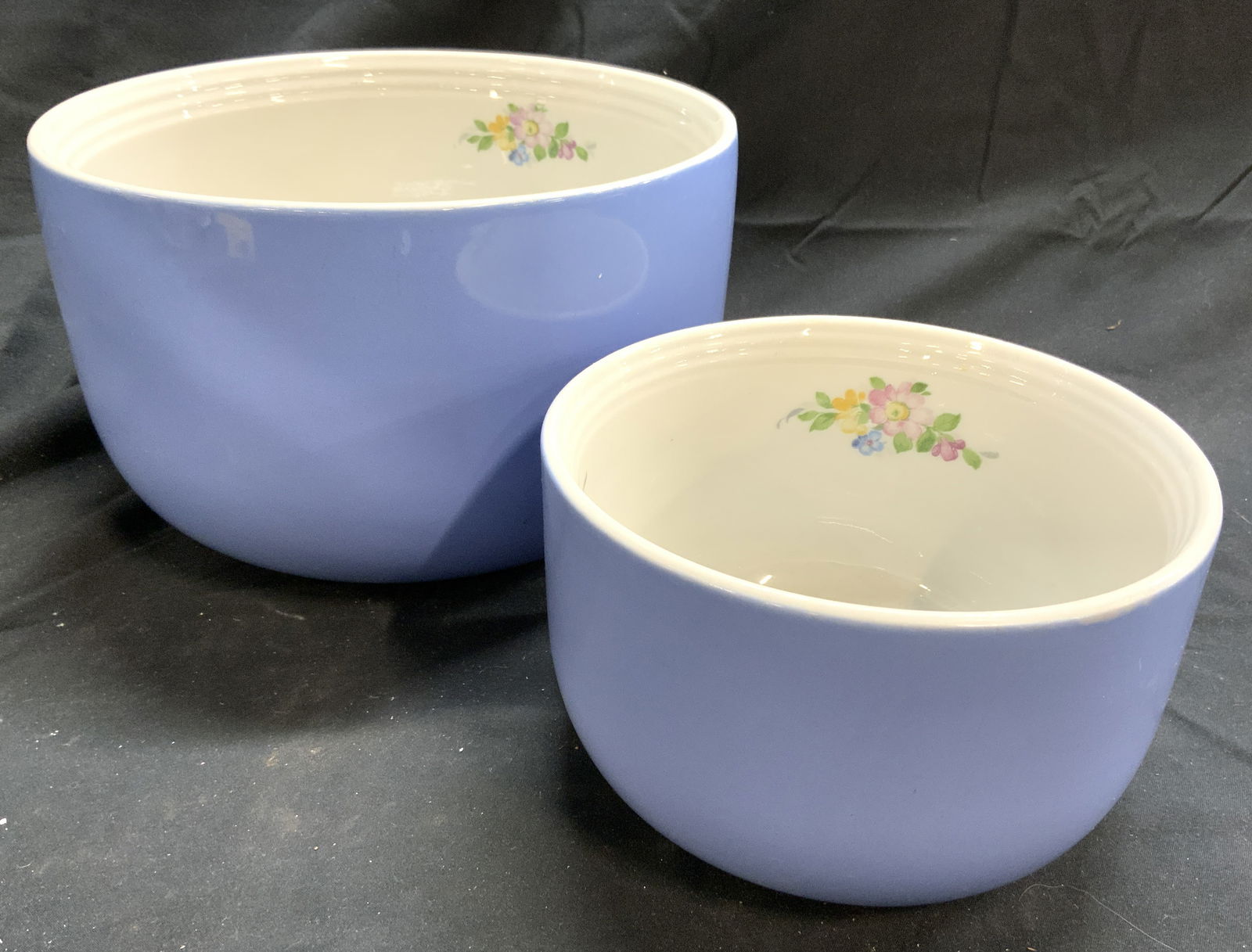 HALLS KITCHENWARE Set 2 Rose Parade Bowls Blue: Undersides are marked HALLS SUPERIOR QUALITY KITCHENWARE USA. Lot includes 2 bowls, each are light blue toned with white interior. Interiors have multi toned floral and leaf detail. Largest Bowl measu
