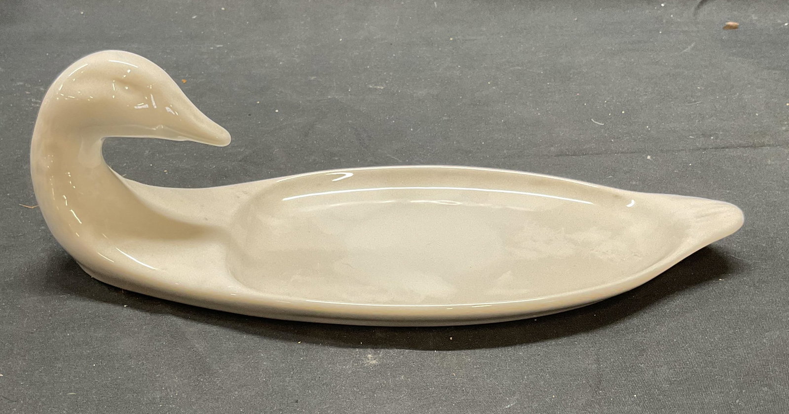 APILCO France Porcelain Duck Dish: APILCO white porcelain duck motif dish with raised head. Trademarked on underside. Made in France. Measures approx. 10.5 x 4.75 x 3.25 inches. Some surface wear including scratching observed. APILCO, 