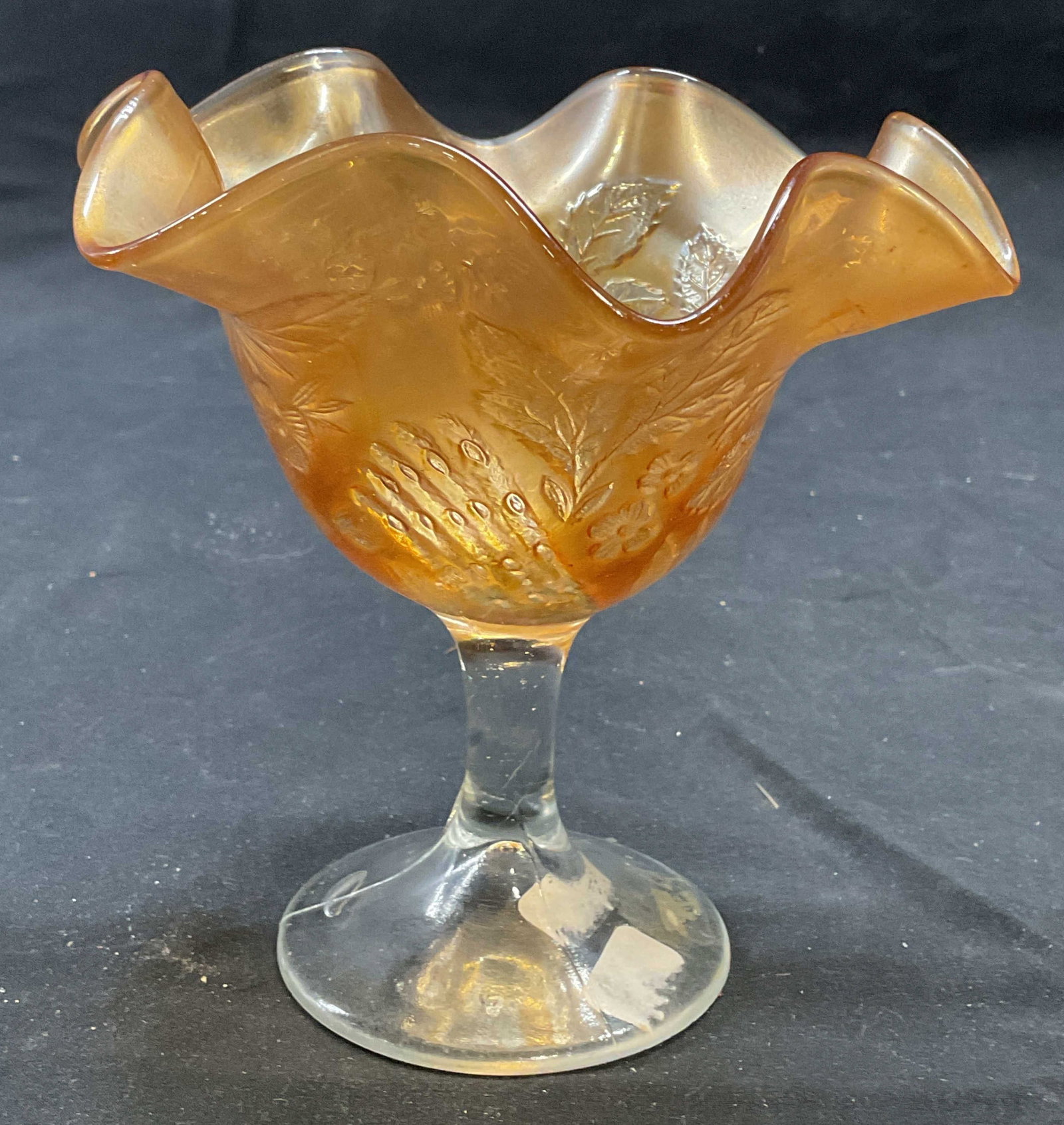 Art Glass Marigold Peacock At The Urn Compote: Art glass footed compote dish with handkerchief rim. Peacock at the Urn pattern. Raised peacock and urn motif on interior. Style of Fenton, no signatures. Measures approx. 5.5 x 5.5 inches. Some surfa