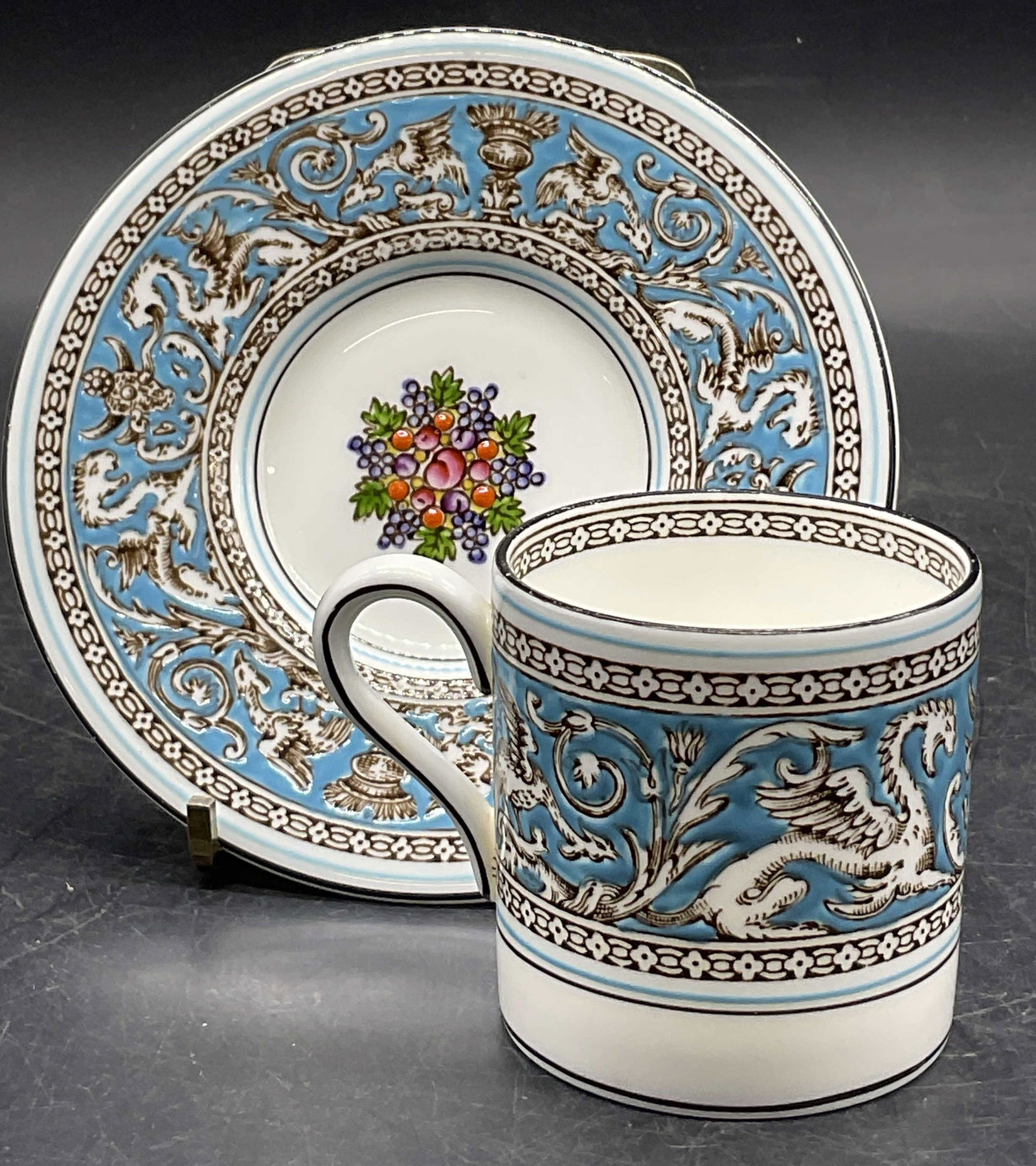 WEDGWOOD Eng Florentine Demitasse Cup & Saucer: A set consisting of a Wedgwood bone china demitasse cup and saucer. Underside signed WEDGWOOD, Bone China, MADE IN ENGLAND, FLORENTINE W2714. Cup measures approx. 2.25H x 3W in. Width includes handle.