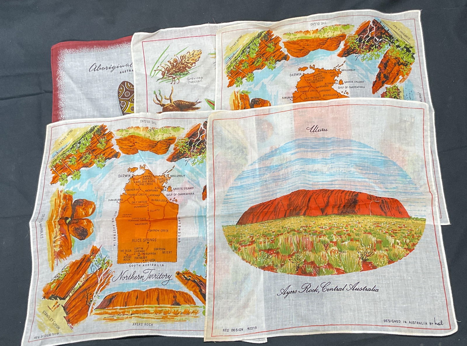 Lot 5 Heil Cotton Australia Souvenir Handkerchiefs: Lot of 5 Heil cotton handkerchiefs. Australia souvenir motifs. Northern Territory, Aboriginal weapons, Ayers Rock, bush Rucker plants. All pieces signed. Measure approx. 12 x 12 inches each. All piece