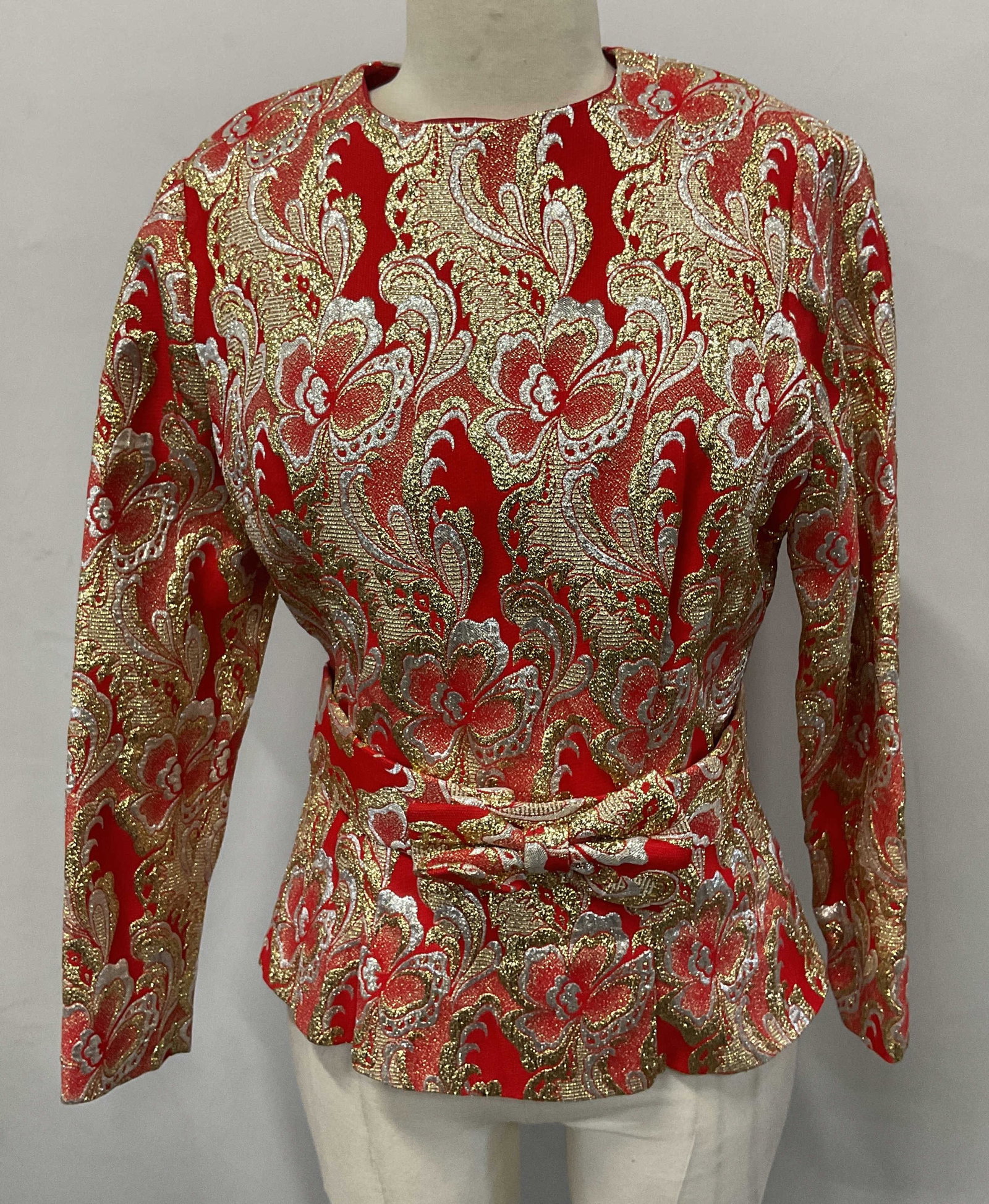 Vintage Red & Gold Floral Belted Top: Vintage red, gold and silver metallic floral pattern long sleeve top with bow detail belt. Measures approx. 16.5 inches across chest. Synthetic material. Some wear to material consistent with exposure