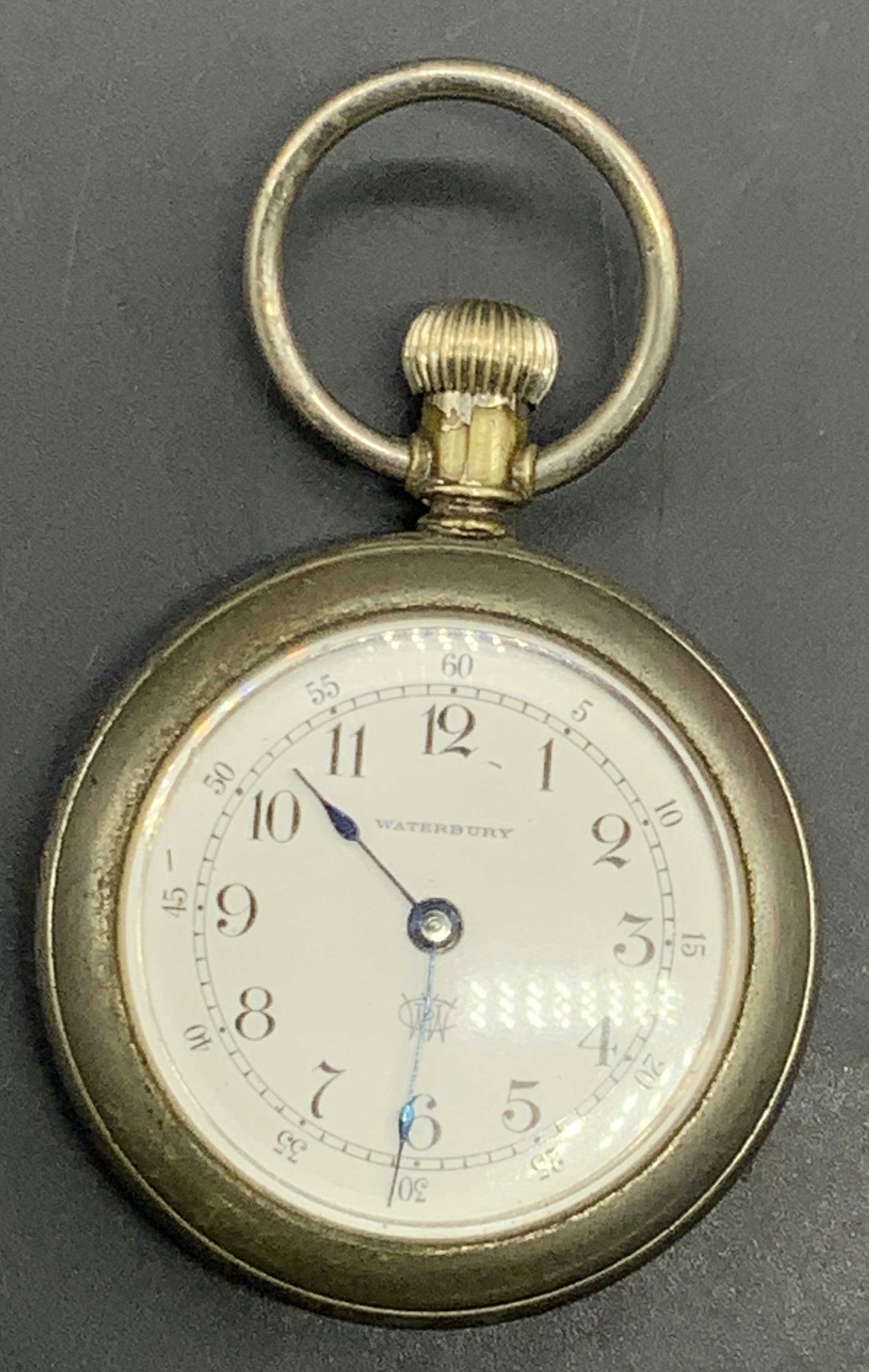 WATERBURY WATCH CO. USA Vintage Pocket Watch: A silver tone metal pocket watch. White watch face reads WATERBURY. Interior reads THE WATERBURY WATCH CO, CONN USA. Not tested for function. Measures approx. 2.5L x 1.75W in. Some wear to metal and s