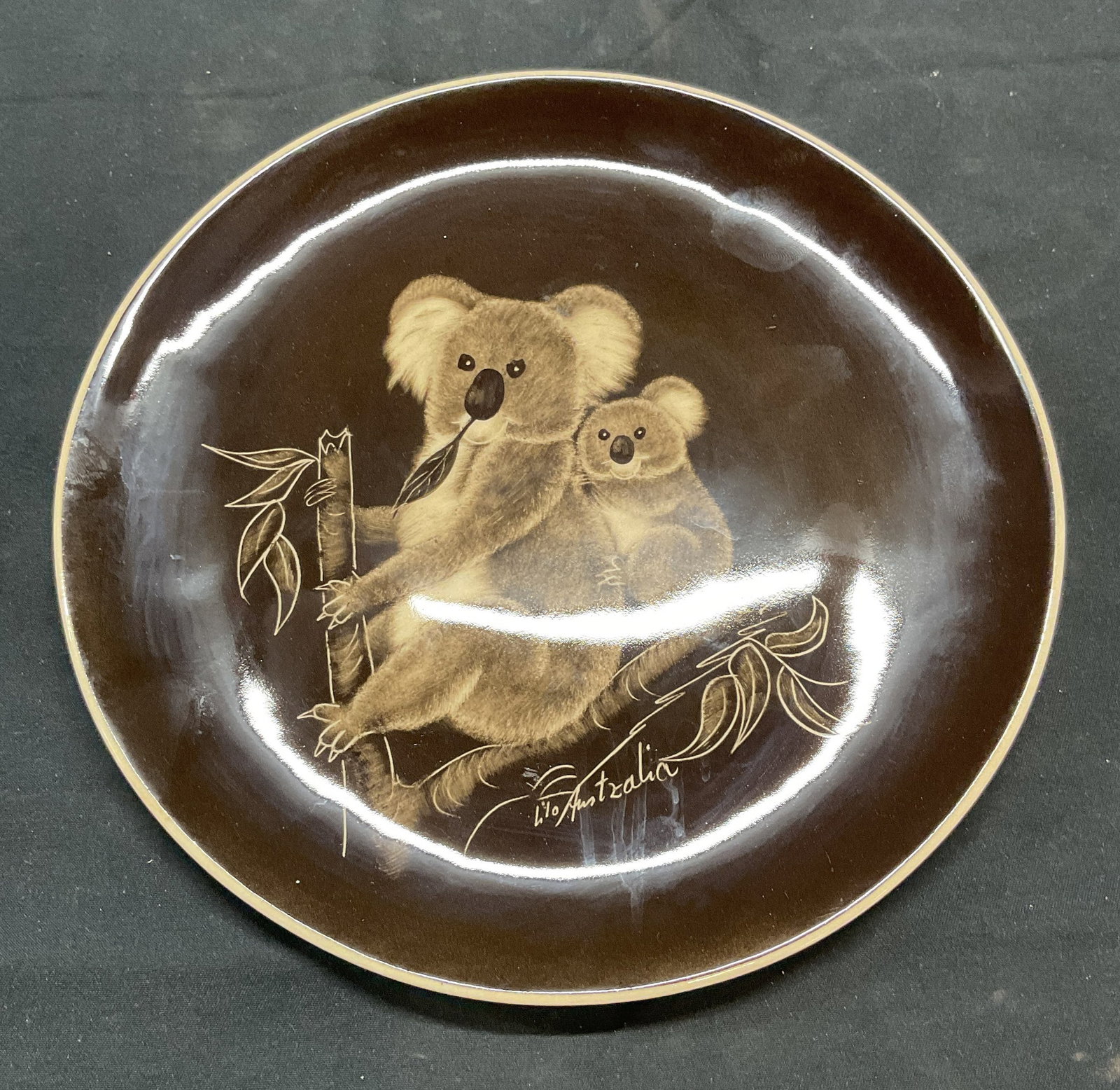 Little Sydney Pottery Brown Koala Plate Australia: The Little Sydney Pottery ceramic plate with koala motif in brown. Artist name on plate. Made in Australia, trademarked to underside. Measures approx. 7.5 inches wide. Some surface wear consistent wit