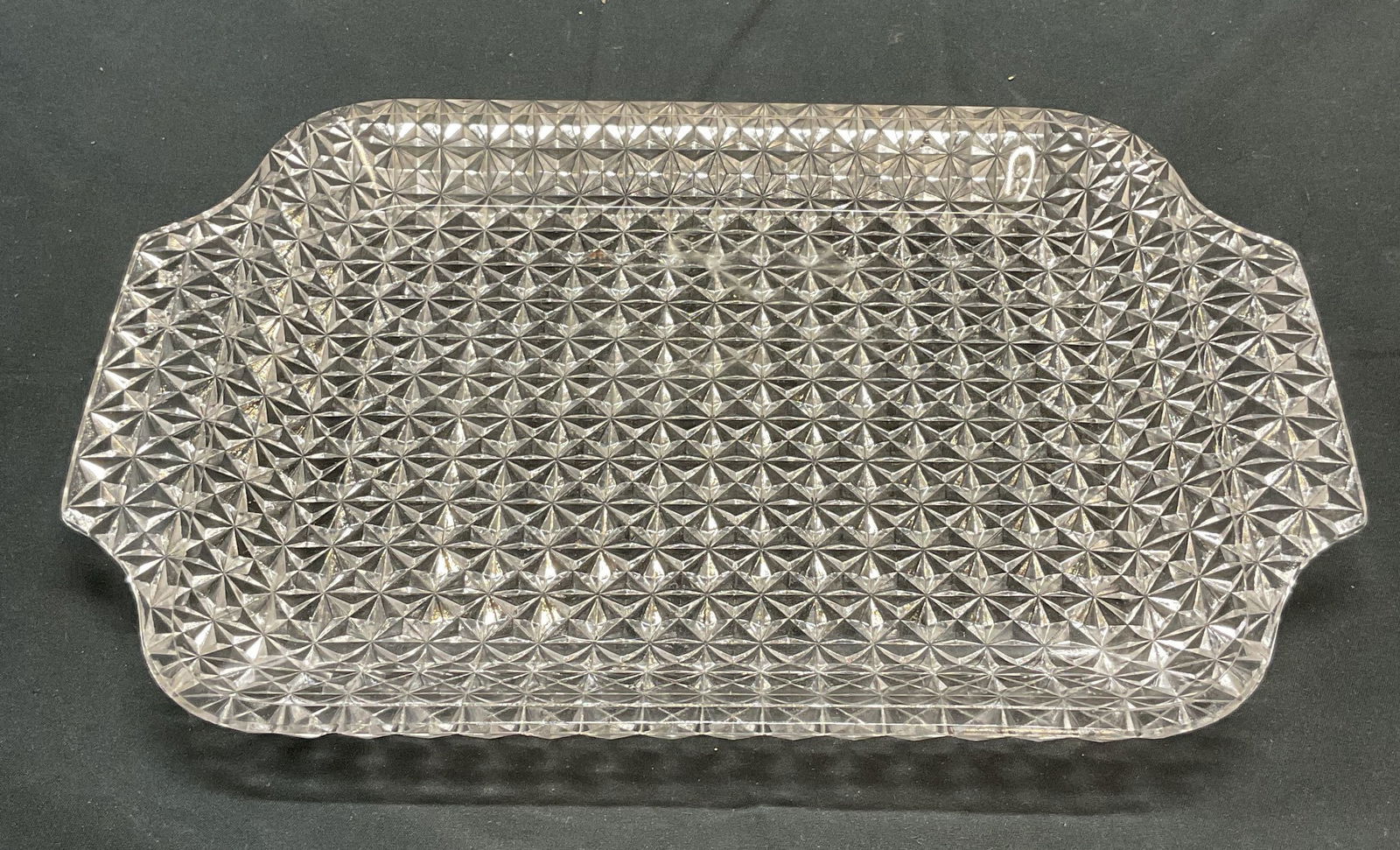 Glass Diamond Pattern Table Tray: Glass table tray with raised geometric diamond pattern on underside. Measures approx. 12 x 7.5 inches. Some surface wear consistent with exposure. Tray, table tray, glass tray, tableware, table decor,