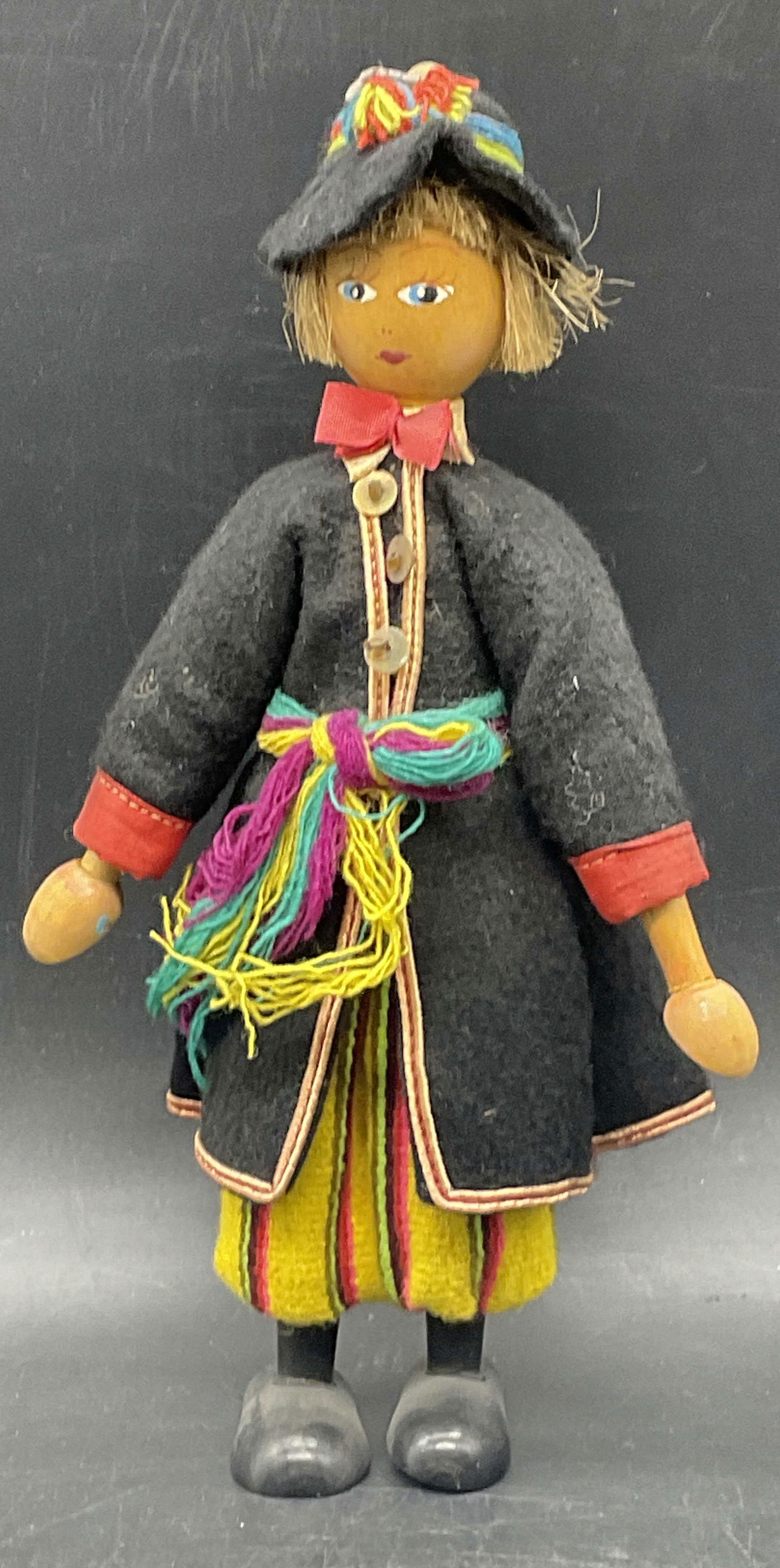 Vintage Handmade Hand Painted Wooden Doll: A vintage handmade and hand painted wooden doll wearing multicolored fabric clothing, Measures approx. 9.5L x 3.5W in. Some wear consistent with age, use, and exposure. Discoloration present. home dec