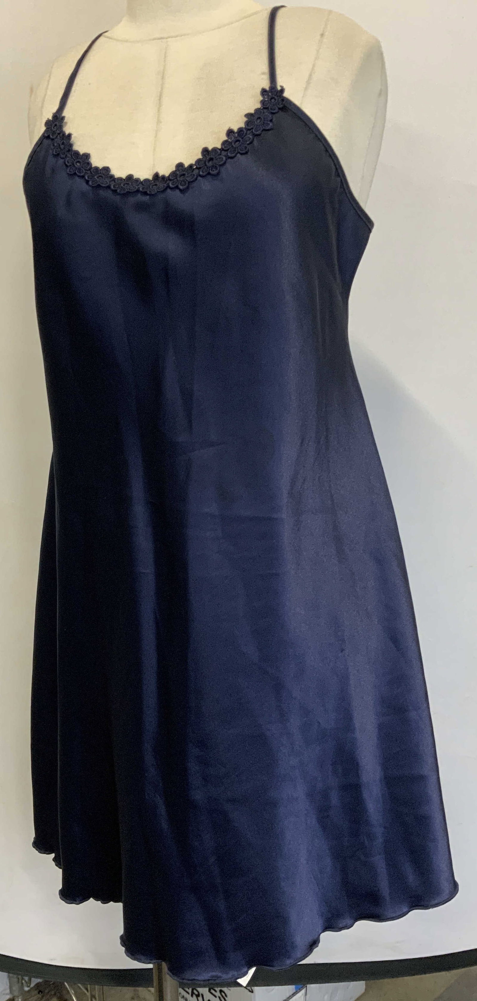 Dark Blue Satin Slip Dress with Floral Embroidery: Dark blue slip dress. 100% polyester. 20 in. Bust. 18 in waist. 31 in. Flare. 34 in length. Womans estimated US2X. Floral embroidered accent on bust line. Discoloration to center of dress and interior