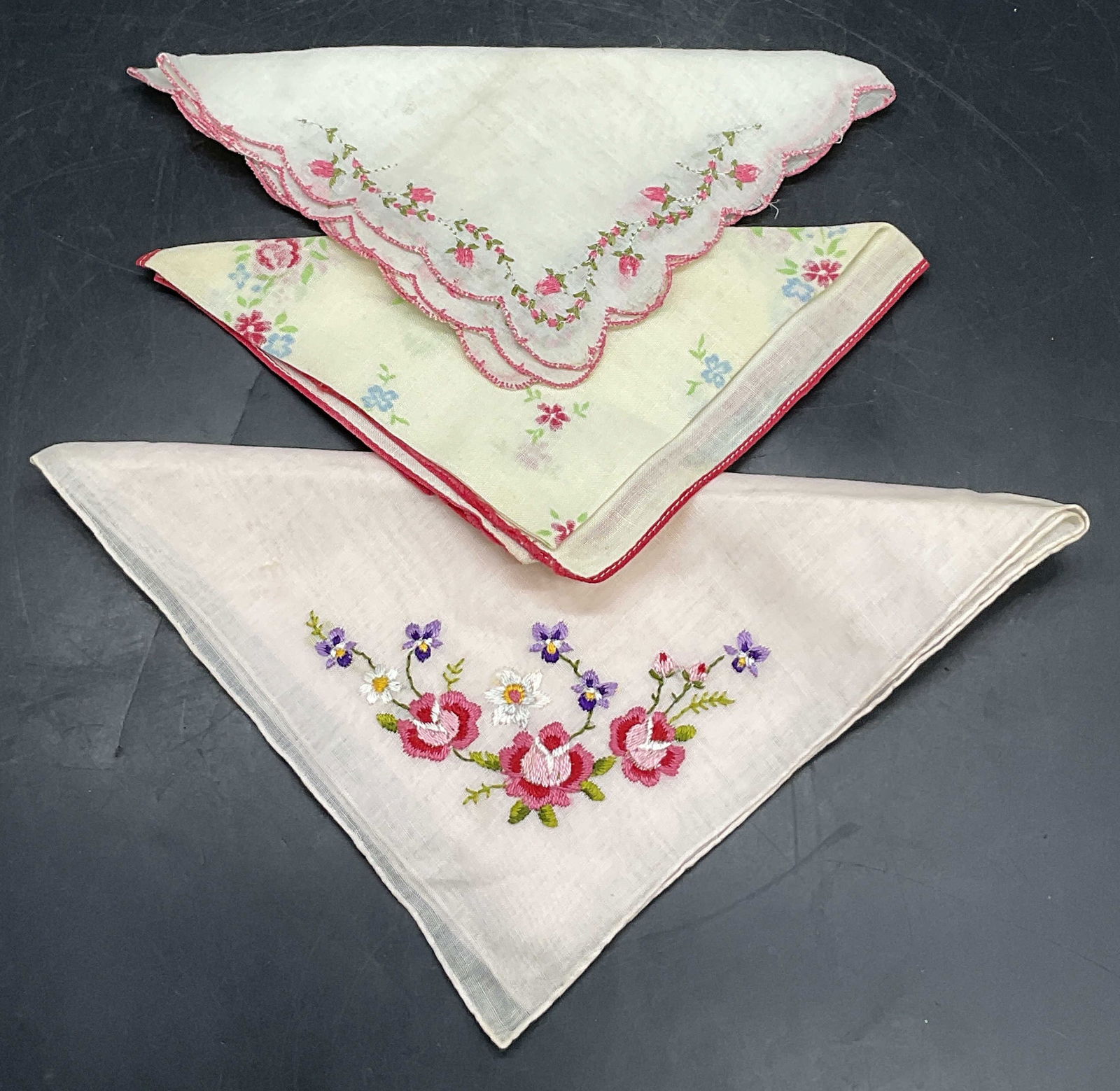 3 Vintage Floral Motif & Embroidery Handkerchiefs: Three vintage soft hand fabric handkerchiefs. Pieces feature floral embroidery of floral motifs. Largest measures approx. 13L x 13W in. Discoloration and surface wear present. home decor, home accents