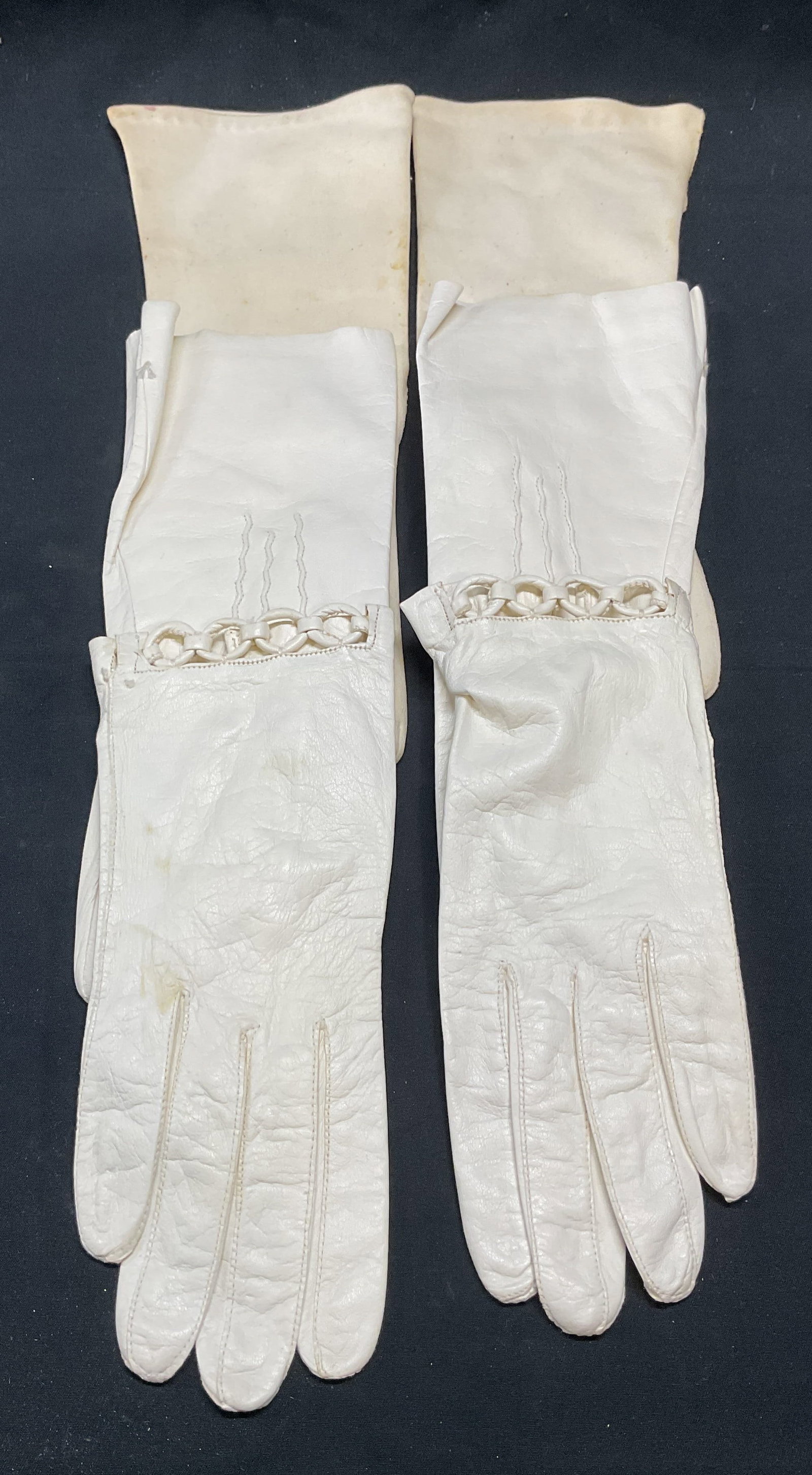 Lot 3 Vintage White Leather & Cotton Gloves: Lot of 3 pairs of vintage white gloves. Cotton gloves by Kayser, leather gloves marked made in Italy, and leather gloves with stretched detail. Longest pair measure approx, 11.5 inches. All pieces hav