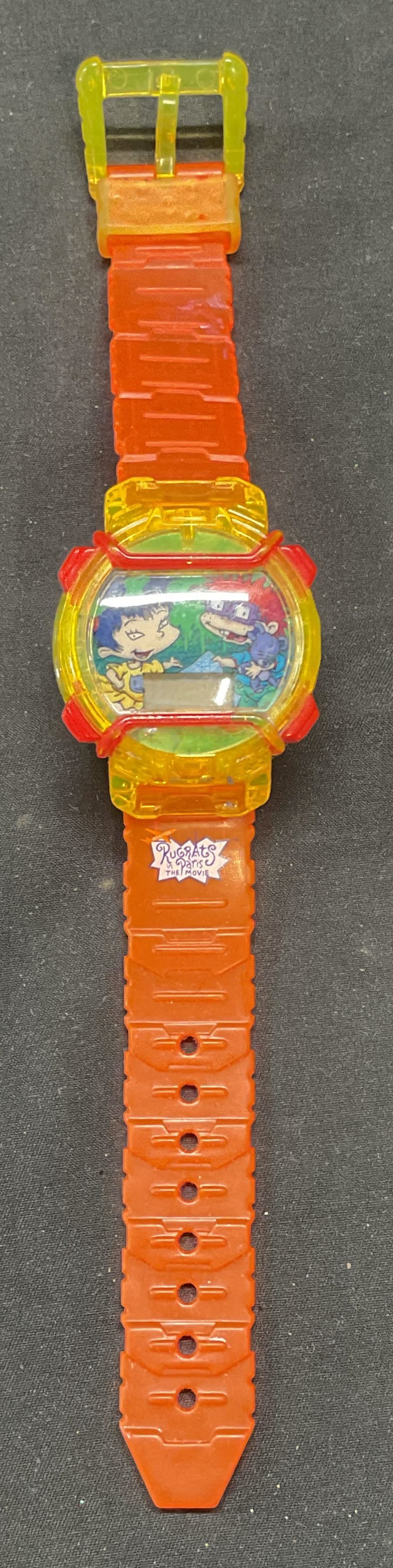 Vntg Burger King Rugrats Movie Watch: Vintage Burger King Rugrats in Paris The Movie Watch. Orange and yellow. Illustrated digital dial. Signed on band. Measures approx. 8.25 inches long. Not tested for function. Some surface wear includi