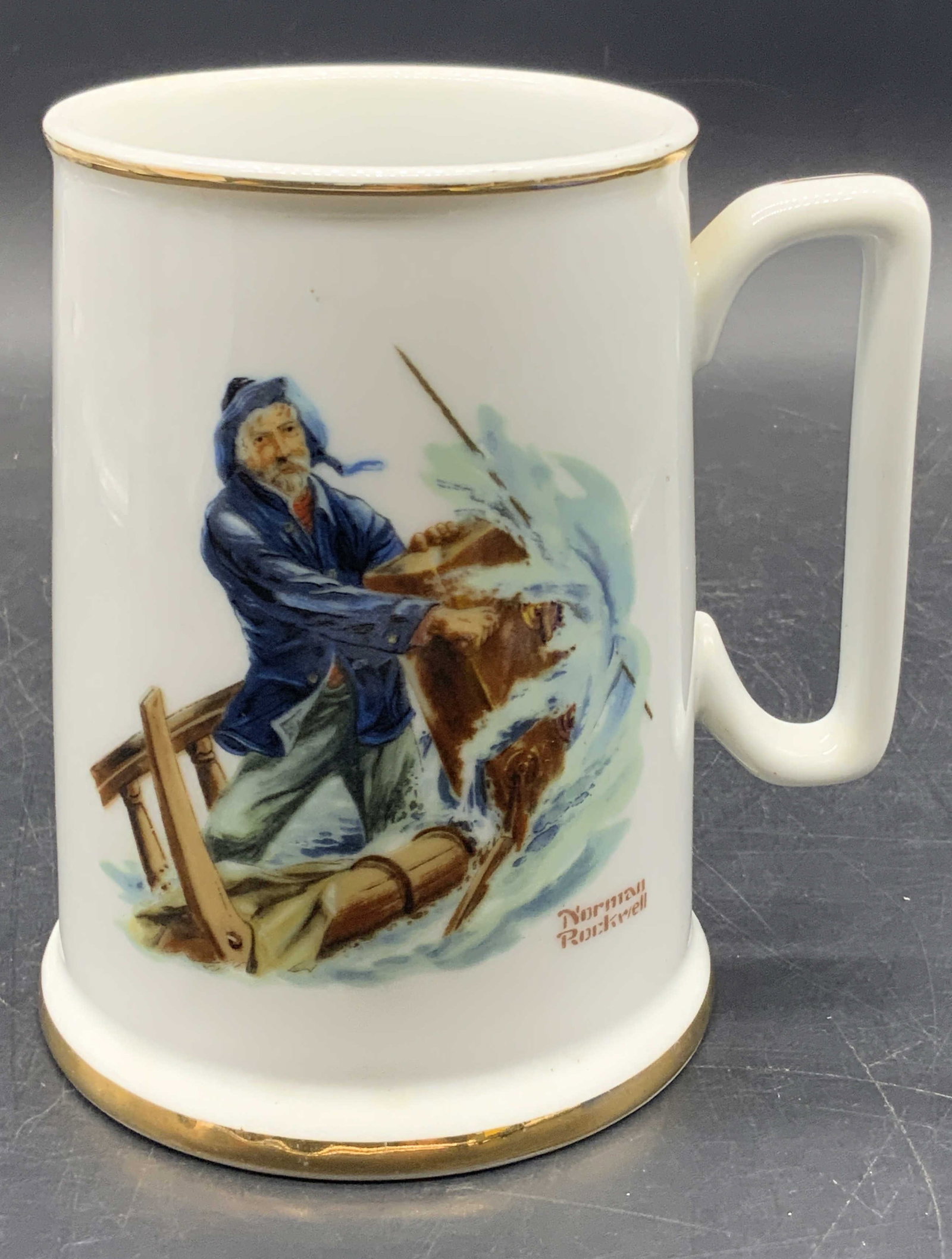 C.1984 Norman Rockwell Museum The Seafarers Mug: A white ceramic mug featuring The Seafarers by Norman Rockwell. Reverse reads The Seafarers by Norman Rockwell. Underside reads The Seafarers Tankard Collection, Braving The Storm, Norman Rockwell, C.