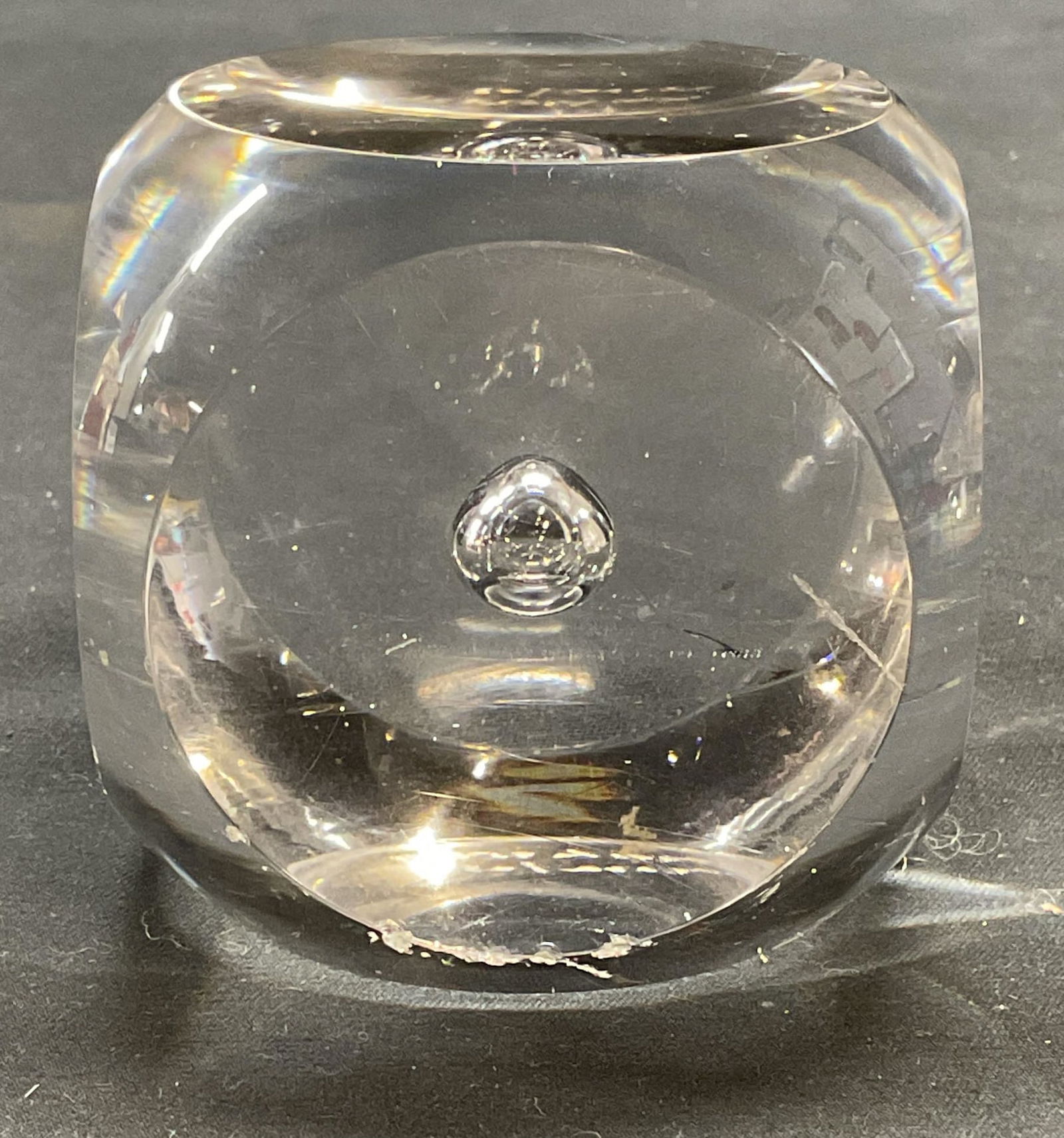 Kosta Boda Morales Art Glass Paperweight: Kosta Boda Mona Morales art glass paperweight. Rounded square with controlled bubble design. Signed on underside. Measures approx. 2.5 x 2.5 x 2.5 inches. Surface wear including scratching and chips o