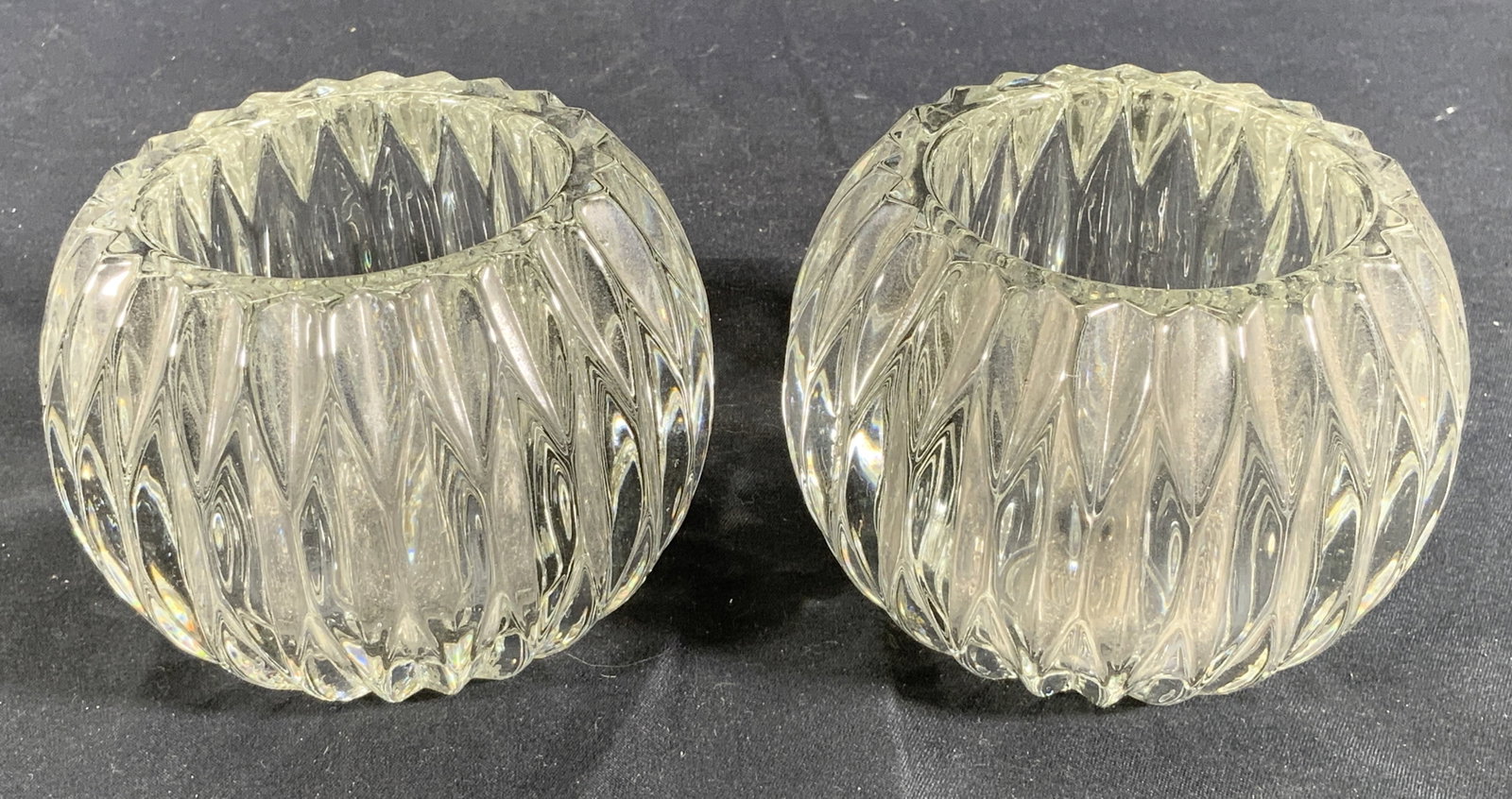 Heavy Pleated Glass Bulbs Candle Holders: Lot 2 Glass candle holders. Glass is heavy and creates a pleated design around the sides towards the top and bottoms. Each measures approx. 2.5 H x 3.5 D in. Minor wear and debris on glass. No apparen