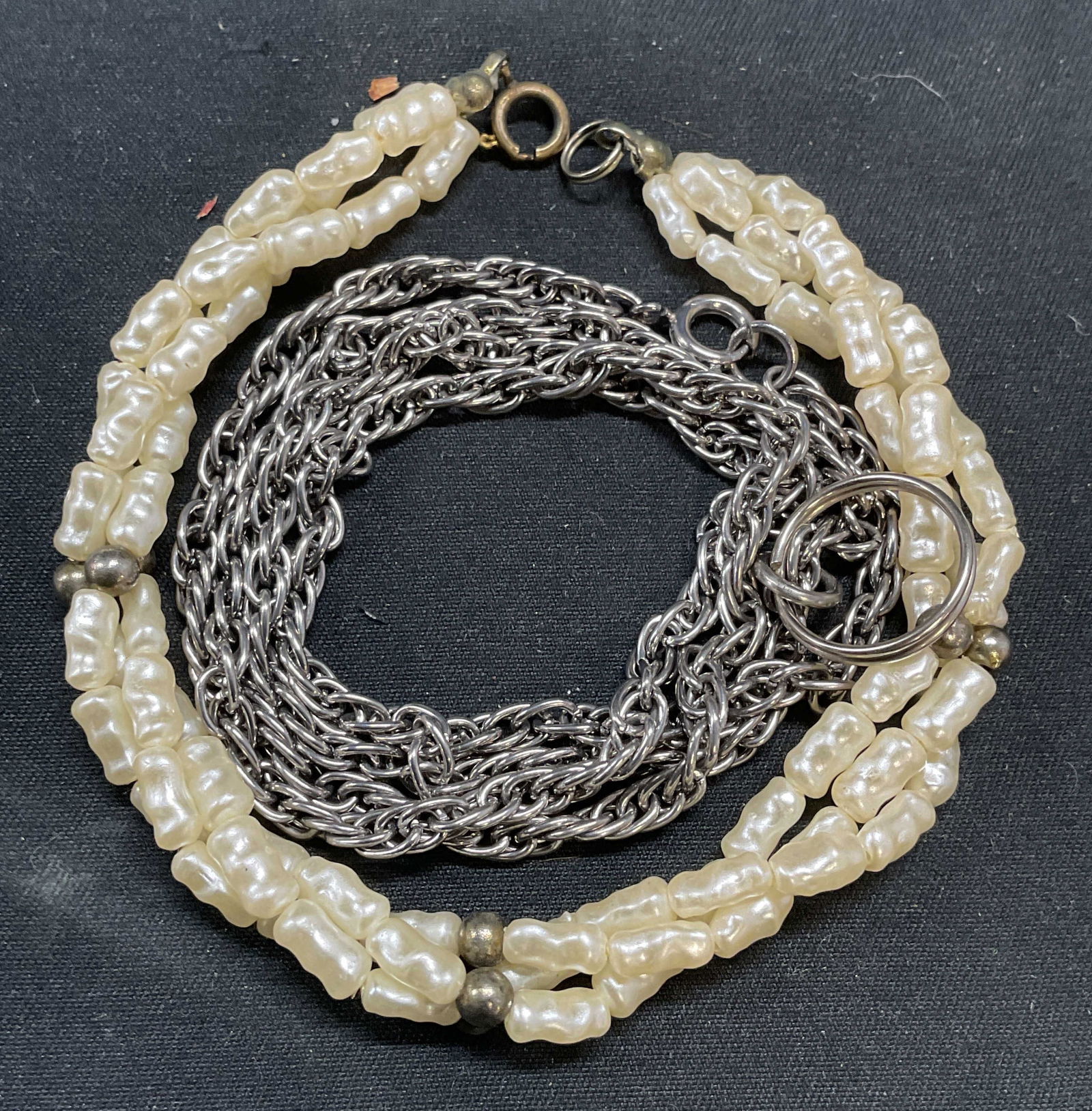 Lot 2 Faux Pearl Bracelet, Silver Tn Necklace: Lot of 2 jewelry pieces. Vintage faux pearl beaded bracelet. Measures approx. 7.5 inches long. Silver tone chain necklace. Drop length approx. 11.5 inches. Some surface wear to both pieces including s