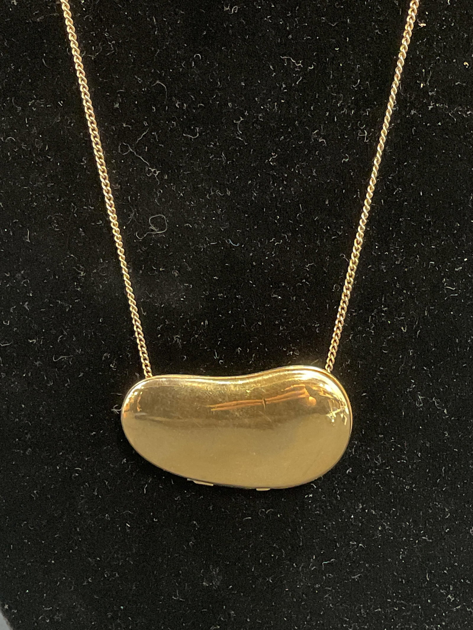 Gold Tone Bean Locket Pendant Necklace: Gold tone necklace with bean shaped locket pendant. Drop length approx. 11 inches. Pendant measures approx. 1 7/8 x 1 inches. Some surface wear including scratching observed. Jewelry, estate jewelry, 