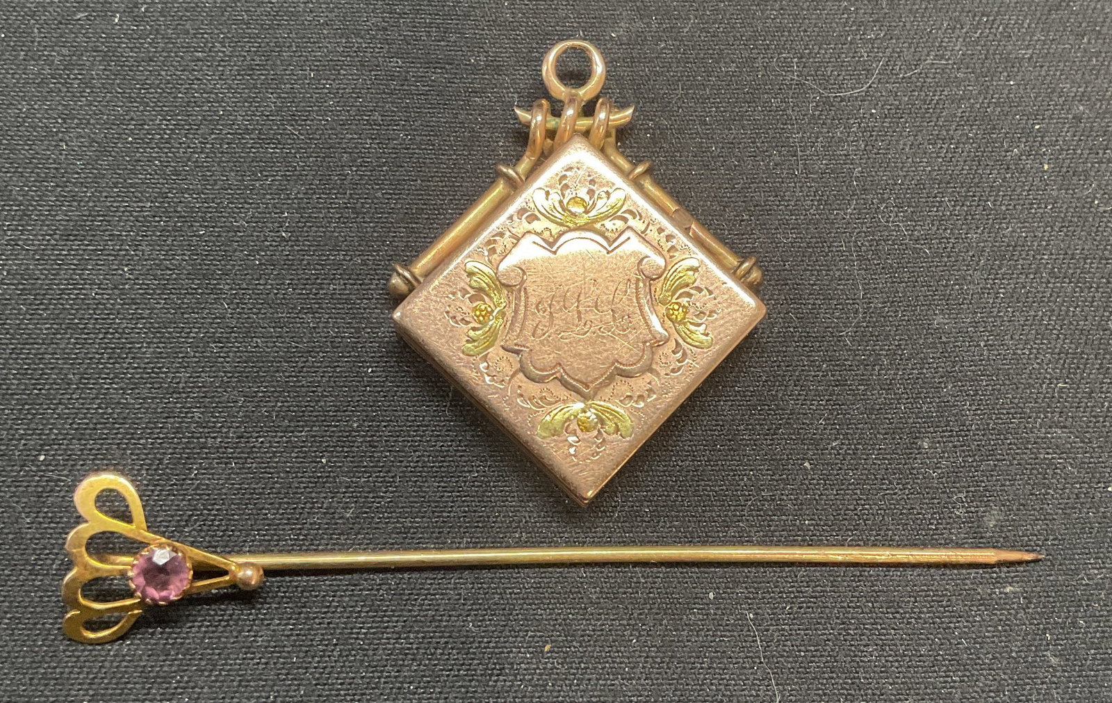 Lot 2 Vintage Gold Pl Locket & Crystal Stick Pin: Lot of 2 jewelry pieces. Vintage gold plated locket with etched monogram. Measures approx. 1.25 x 1 inches. Gold tone stick pin with purple crystal decoration. Measures approx. 2.5 inches long. Some s