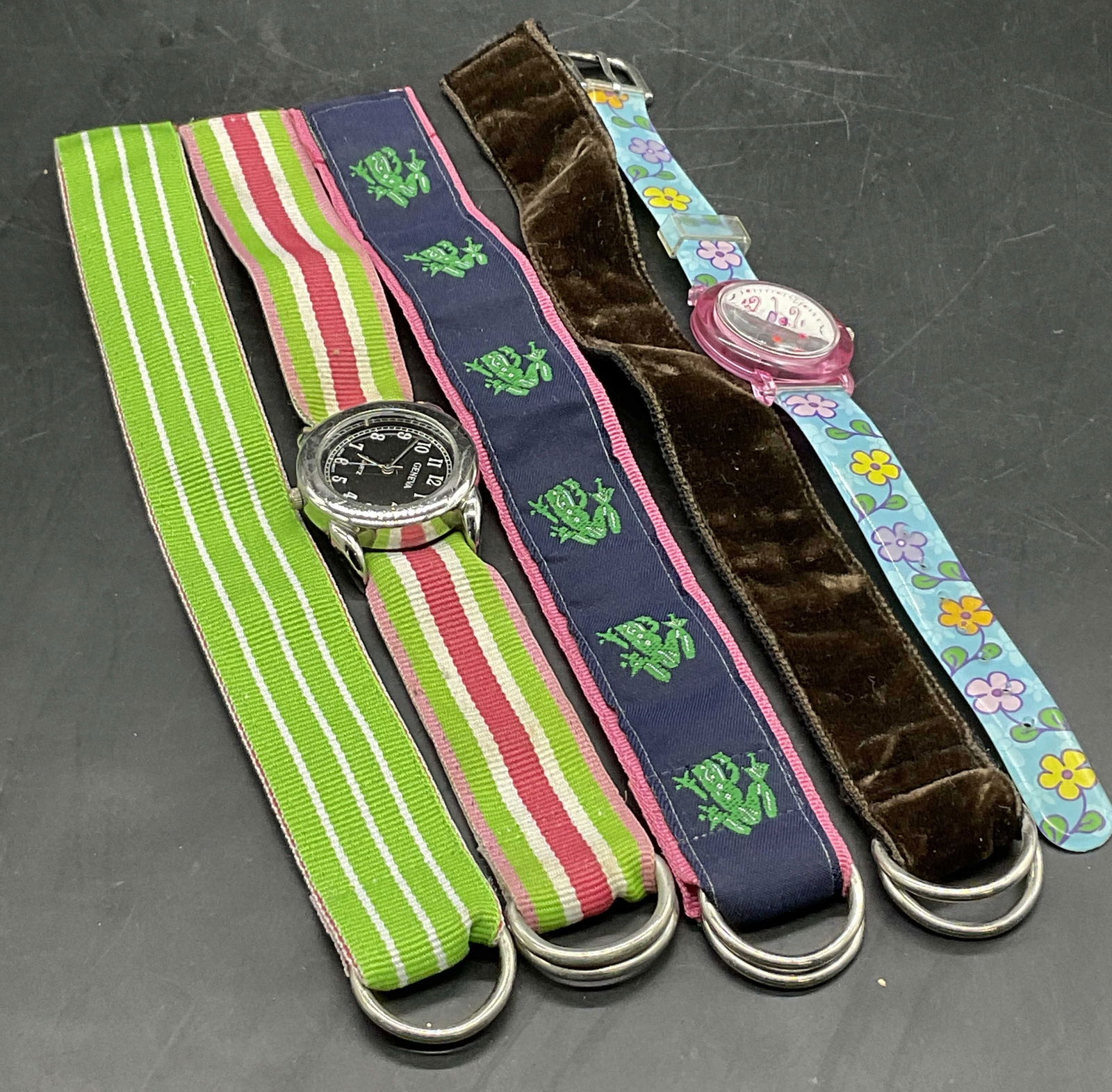 Lot 5 Wrist Watches & Bracelets, GENEVA & LUCKY+: Two wrist watches and three bracelets. One watch features a silver tone metal face and a fabric band, obverse reads GENEVA. The other watch is crafted from composite materials and the face reads LUCKY