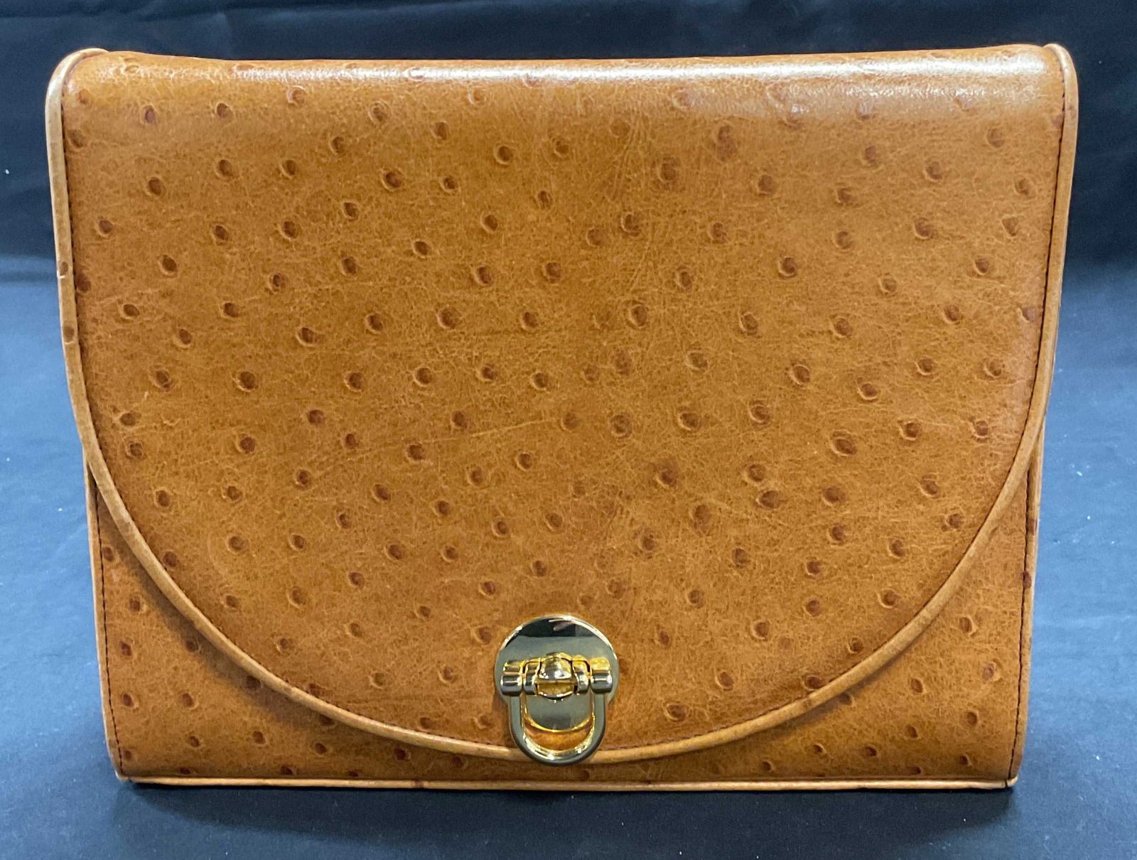 Frenchy of California Tan Embossed Leather Handbag: Vintage Frenchy of California ostrich embossed tan leather handbag. Signed on interior. Fold over flap and gold tone hardware. 2 pockets to interior. Includes hand mirror. Measures approx. 8.5 x 2 x 7