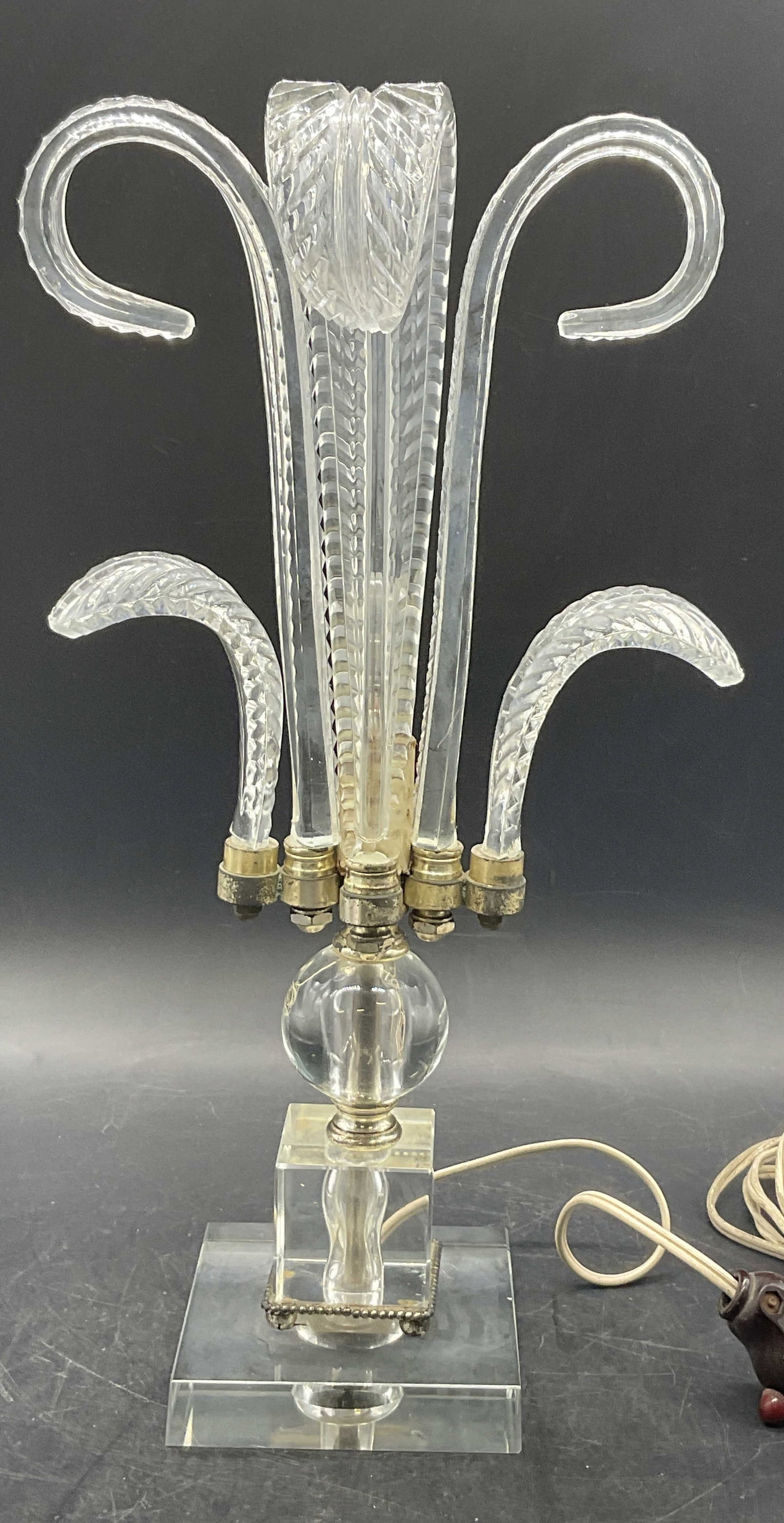 Vintage Hollywood Regency Style Glass Plume Lamp: A vintage Hollywood regency style glass plume lamp. Curled glass plumes to the upper and geometric sphere & square base. Silver tone metal hardware and accents. Corded. Measures approx. 15H x 7.5W in.