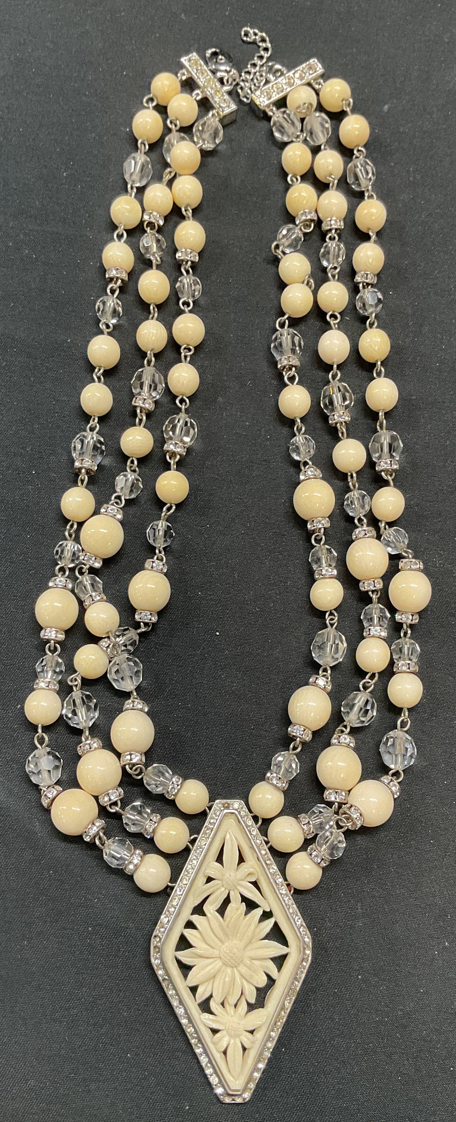 Yamada Tokyo White Crystal Beaded Necklace: Vintage Yamada Tokyo white and colorless crystal beaded pendant necklace with reticulated flower motif pendant. Signed on pendant. Drop length approx. 8.5 inches. Pendant measures approx. 2.5 inches l