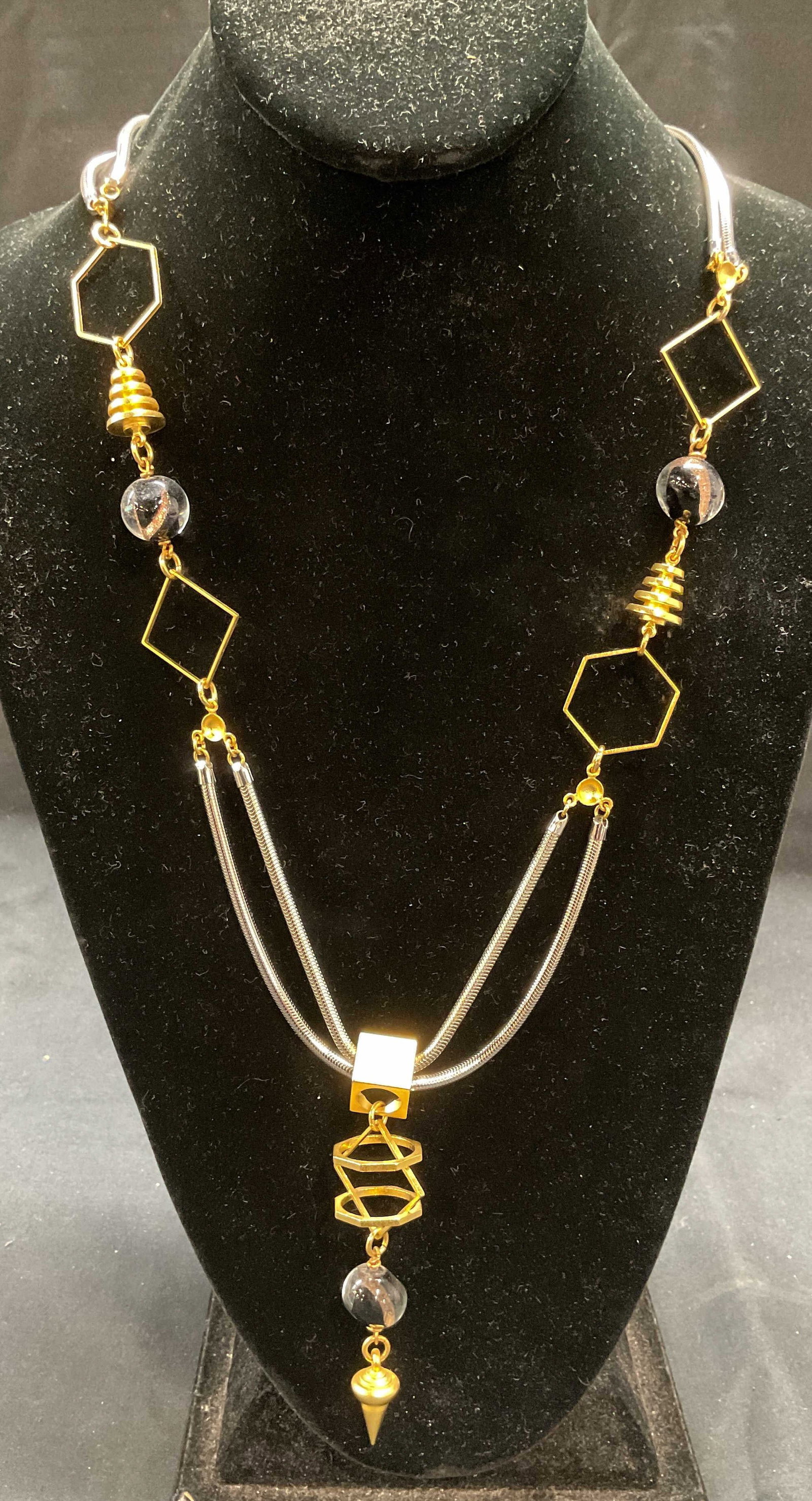 Silver & Gold Tone Art Glass Pendant Necklace: Silver tone chain necklace with gold tone geometric shaped pendants and art glass beads. Drop length approx. 16 inches. Pendant length approx. 3.5 inches. Some surface wear including scratching observ