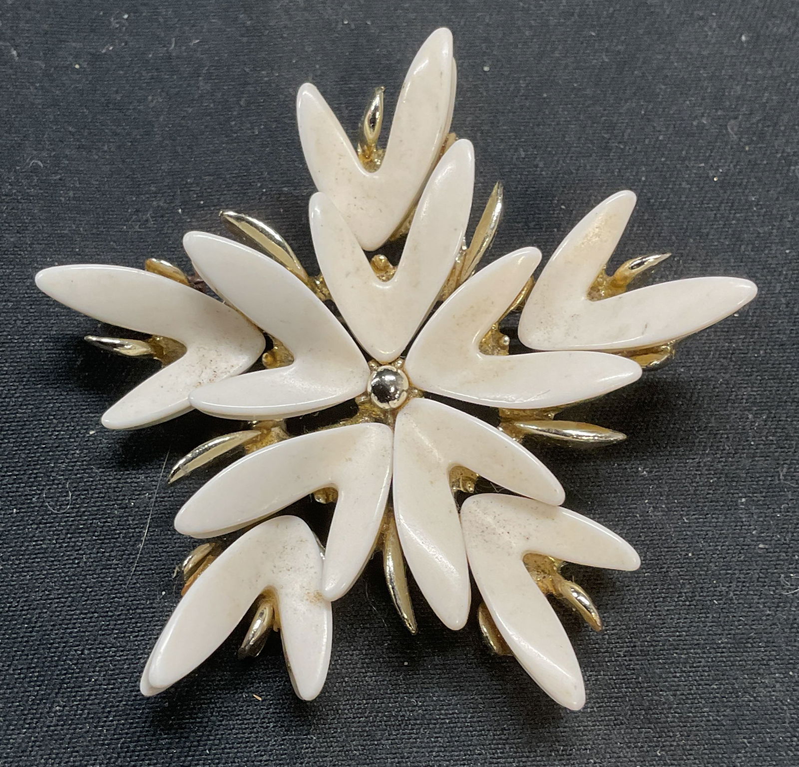 Vintage Claudette White Lucite Flower Brooch: Vintage Claudette white lucite and gold tone flower motif brooch. Signed on underside. Hinge pin on underside. Measures approx. 2 inches wide. Some surface wear including scratching observed. Jewelry,