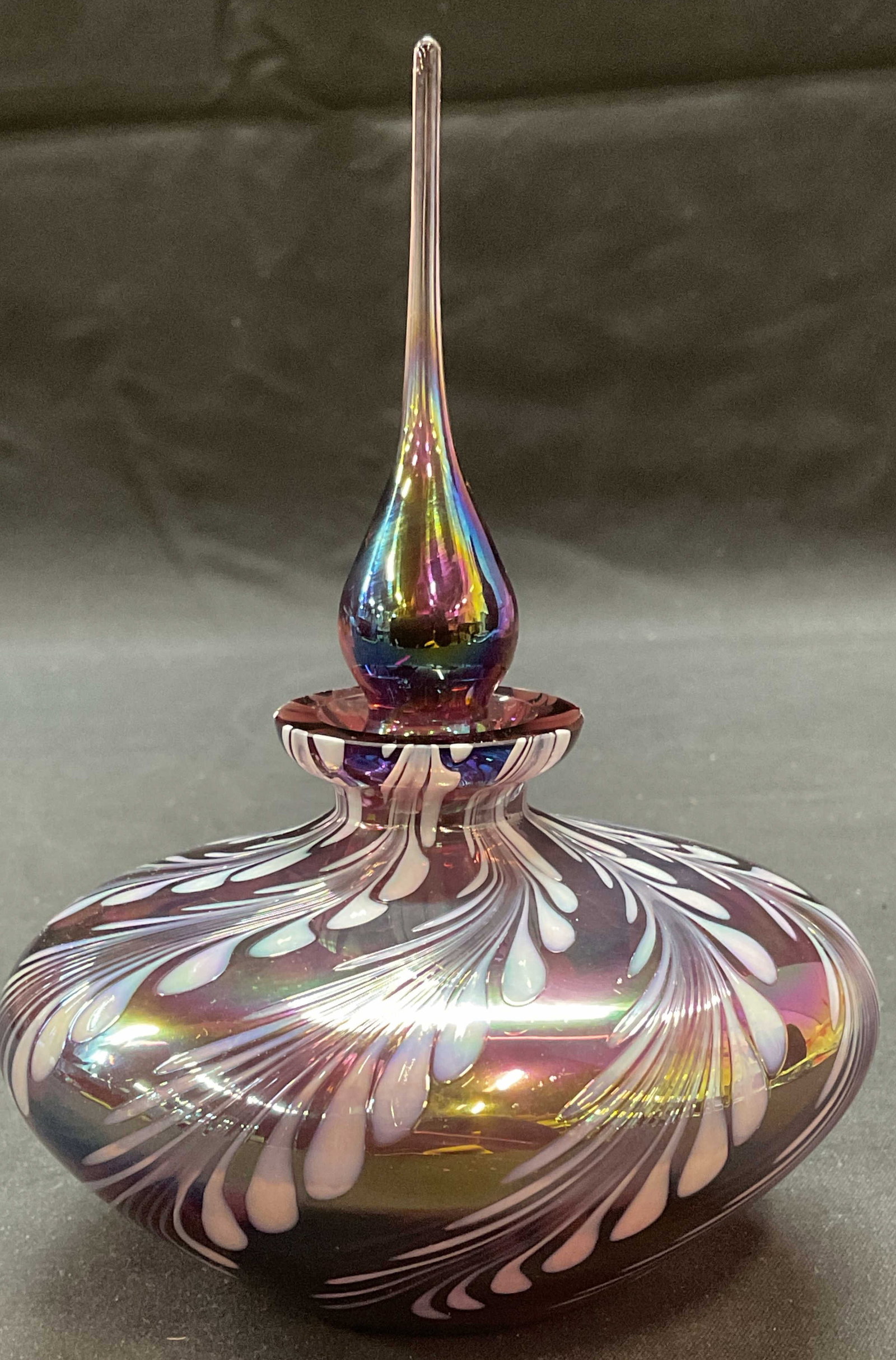 Opaline Feather Pull Art Glass Perfume Bottle: Handblown purple iridescent and Opaline feather pull design art glass perfume bottle with stopper. Measures approx. 4 x 5.75 inches. Stopper appears stuck. Some surface wear including scratching obser