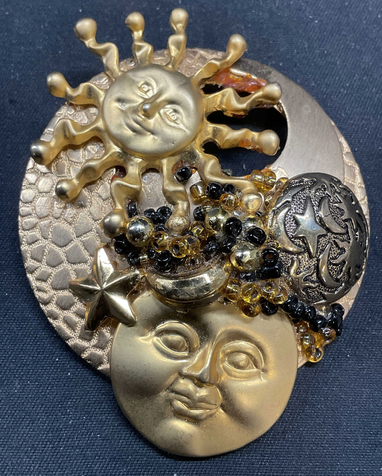 Handmade Gold Tone Sun & Moon Brooch: Handmade gold tone brooch with sun and moon motifs. Hinge pin on underside. Measures approx. 2.5 inches long. Some surface wear including scratching observed. Some residue observed. Jewelry, estate je