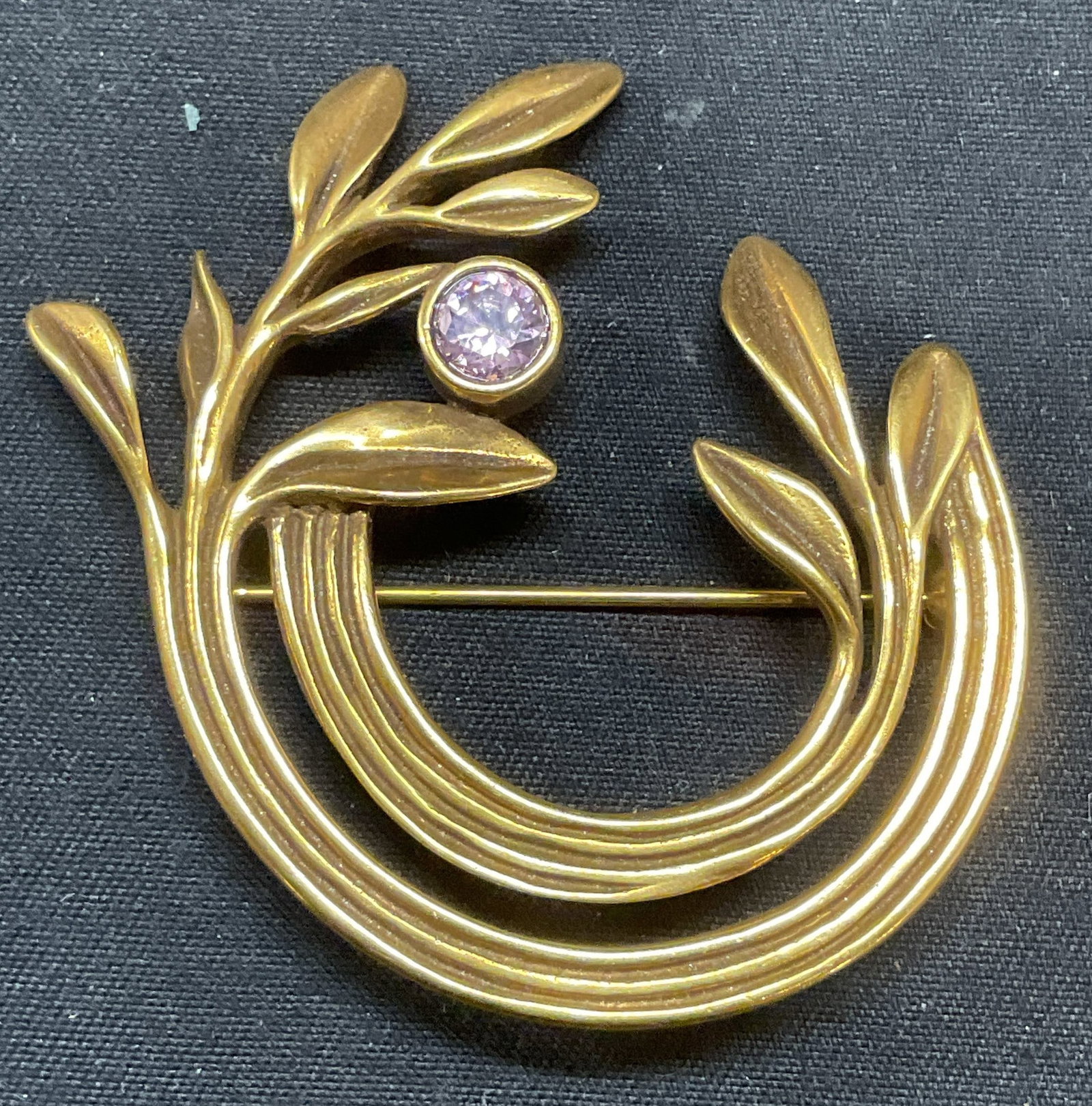 Vtg Hadassah Founder Olive Branch Brooch 1990: Vintage 1990 Hadassah Founder gold tone olive branch motif brooch with purple crystal. Signed on underside. Hinge pin on underside. Measures approx. 1.75 x 1.75 inches. Some surface wear including scr