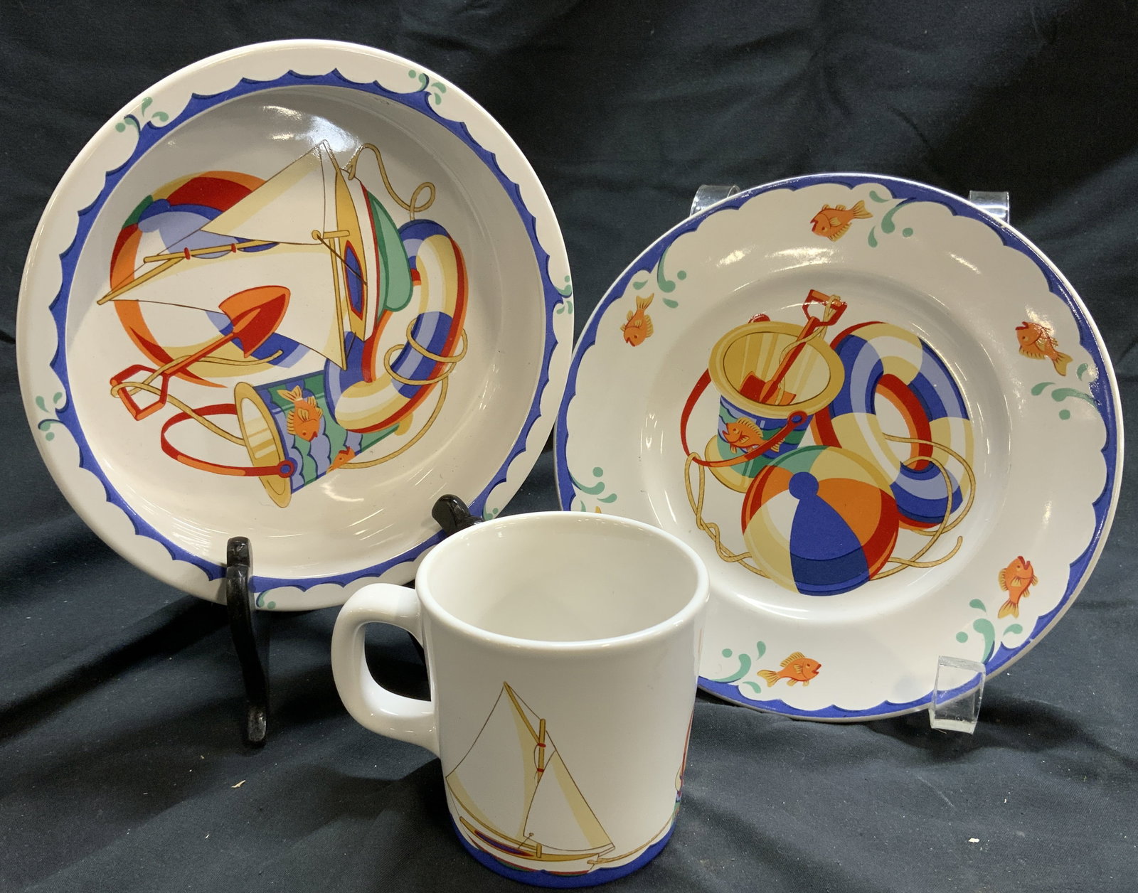 TIFFANY & CO Lot 3 Tiffany Sunrise Plate Cup & Bowl: Undersides are marked TIFFANY & CO TIFFANY SUNRISE. Lot includes 1 cup, 1 bowl & 1 plate. Each piece is white with multi toned beach ball, lifesavers & sand bucket detail. Each piece is porcelain. Pla