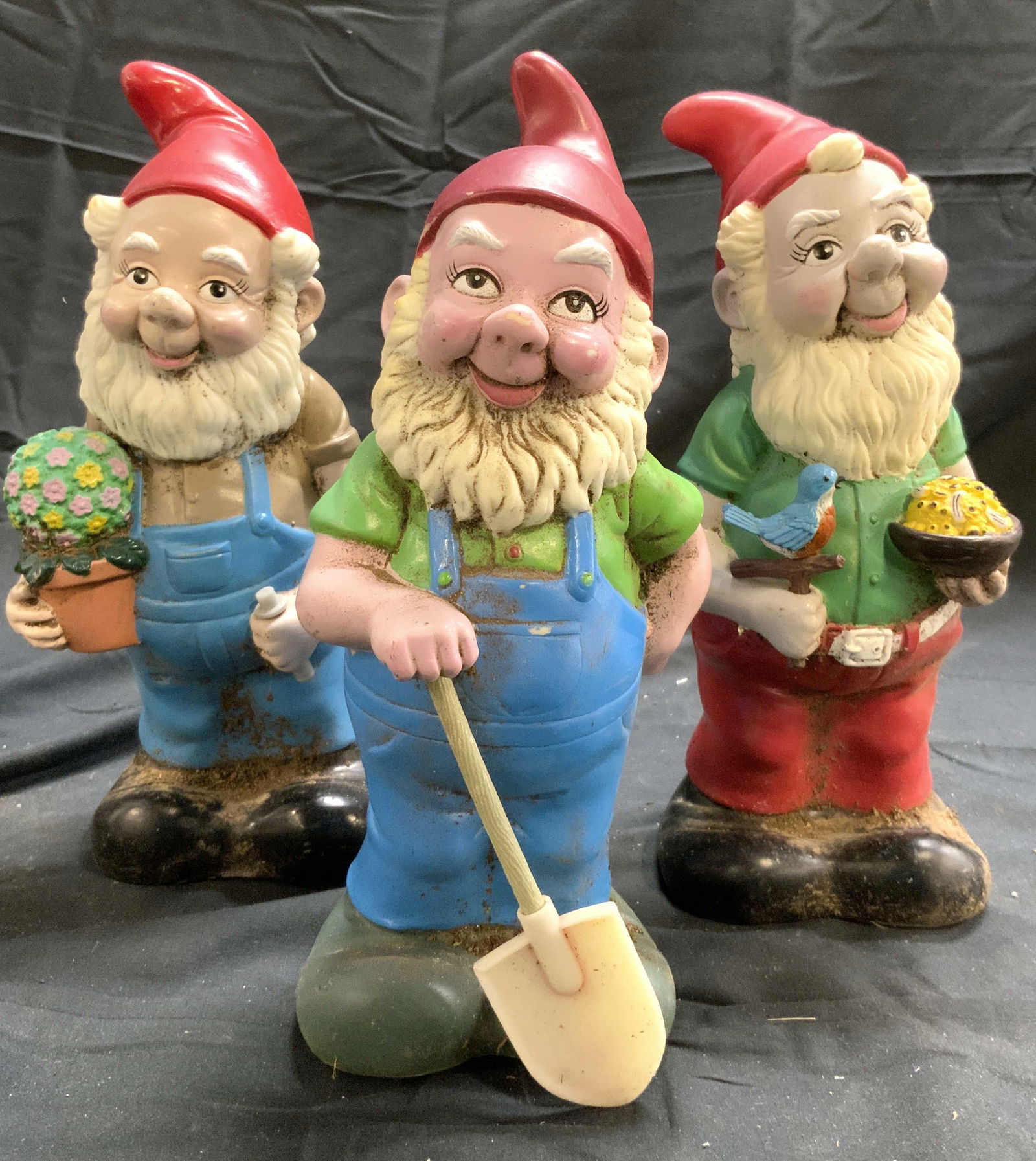 ARTLINE Lot 3 Vntg Garden Gnomes: Undersides each read ARTLINE. Lot includes 3 garden gnomes. Each appear to be resinous possibly plastic. Includes 1 gnome with shovel, 1 holding a flower pot, and 1 holding a bird and bowl largest gar