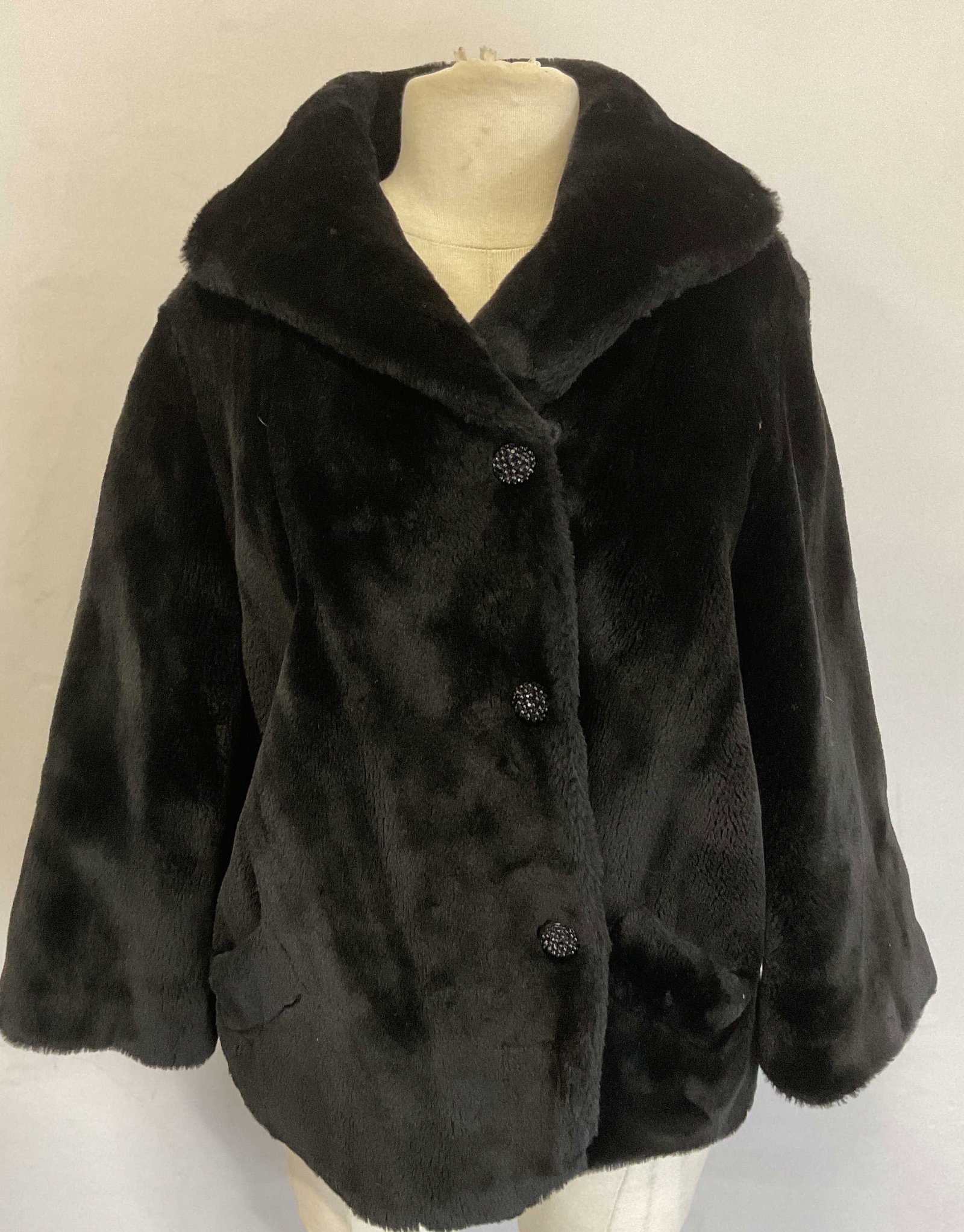 Vintage Black Faux Fur Coat: Vintage black faux fur coat. 2 pockets and hook and eye closure with decorative buttons. Measures approx. 21 inches across chest, 24 inches from shoulder to hem. Some wear to material and blemishes on
