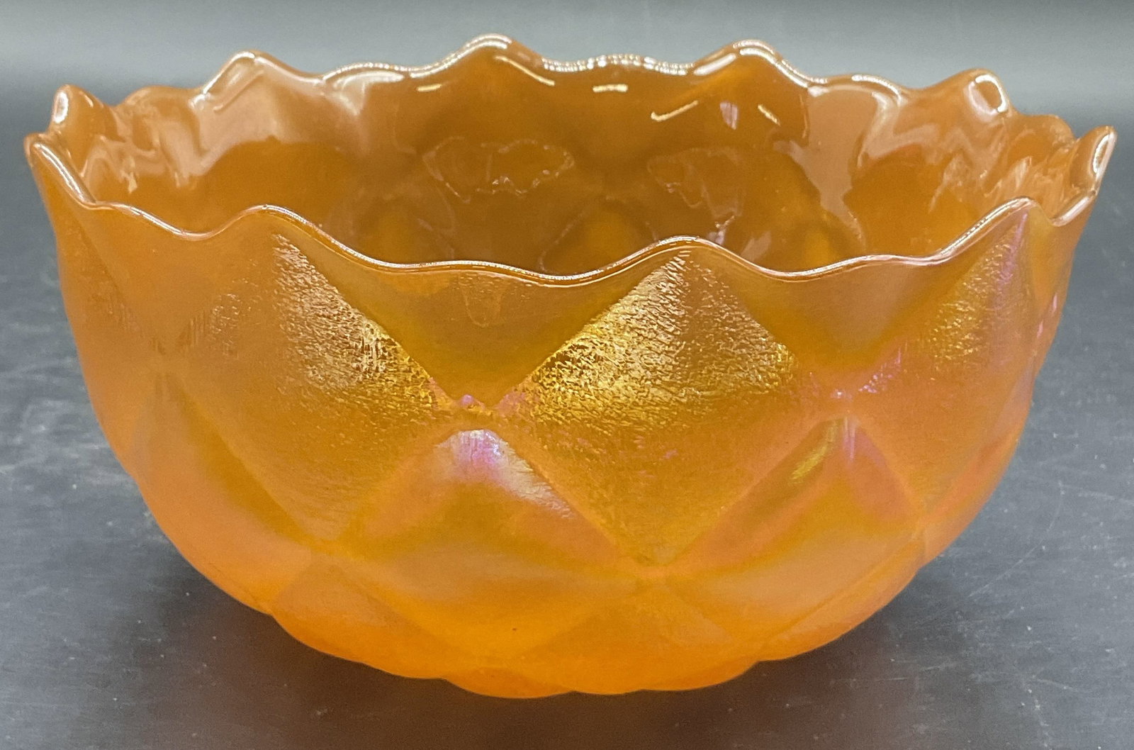 Vintage Orange Carnival Luster Glass Bowl: A vintage orange carnival luster glass bowl with a scalloped rim. Textured exterior, smooth interior. Measures approx. 3H x 6.5W in. Surface wear consistent with age, use, and exposure. home decor, ho