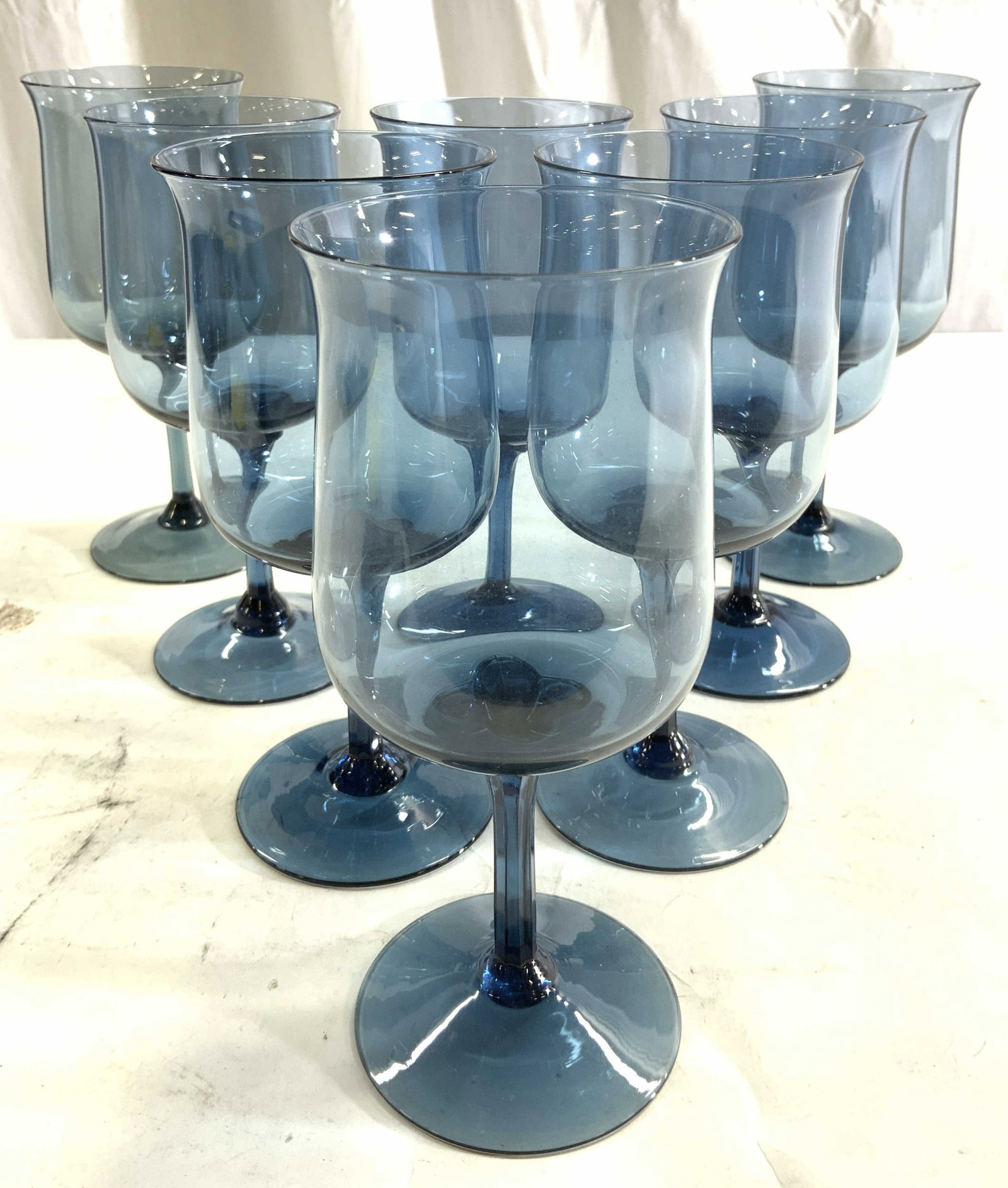 Set 6 Art Glass Goblets Blue: Goblets are each blue toned and glass. Each goblet has rim which leans slightly outwards. Bases each have circular forms. Goblets each measure approximately 7 inches tall 3 inches wide. Art glass, art