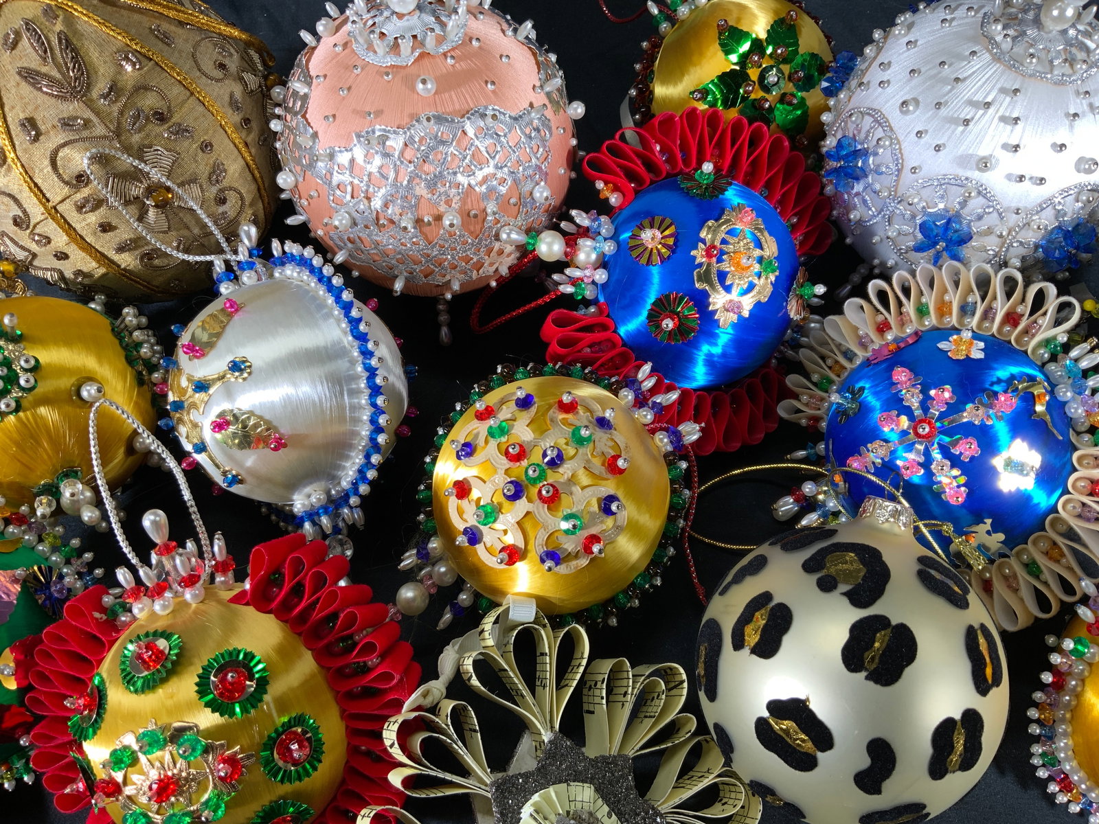 Lot 15 Artistically Decorated Christmas Ornaments: Lot 15 multicolored beaded Christmas ornaments. Each uniquely decorated with beaded pins and ribbons. Largest ornament measures approx. 5 in. diameter. Some ornament may have missing beads. Some ornam