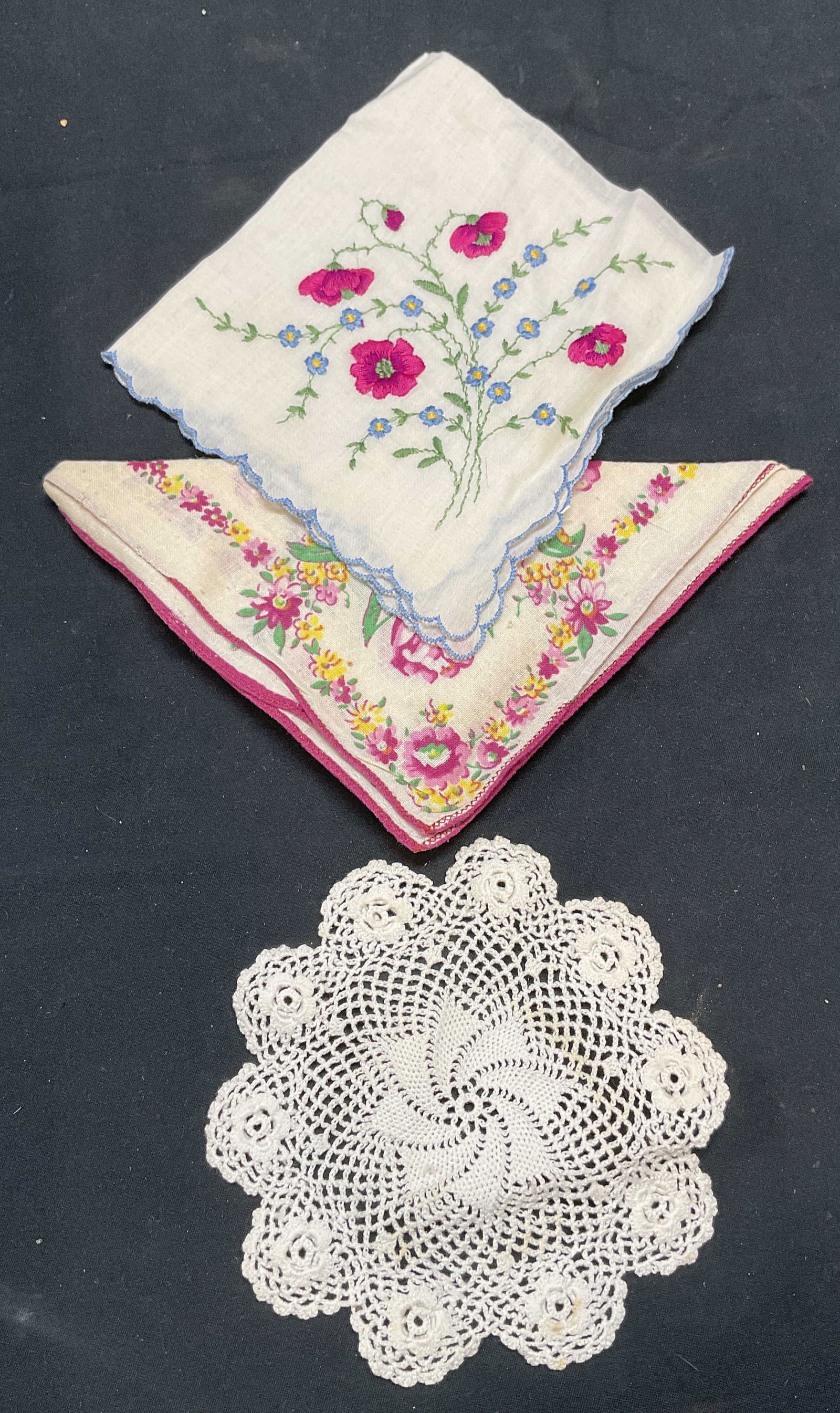 Lot 3 Vintage Floral Handkerchiefs & Doily: 2 vintage cotton handkerchiefs with printed floral and embroidered floral patterns. 1 white lace doily. Largest piece measures approx. 11.5 x 11 inches. All pieces have some wear to materials includin