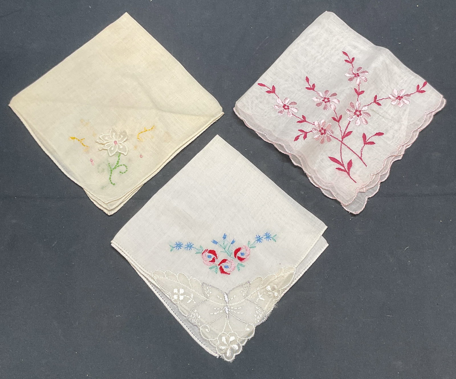 Lot 3 Vintage Embroidered Floral Handkerchiefs: Lot of 3 vintage white cotton handkerchiefs with embroidered floral and butterfly patterns. Largest measures approx. 11 x 10.5 inches. All pieces have some wear to material including blemishes observe