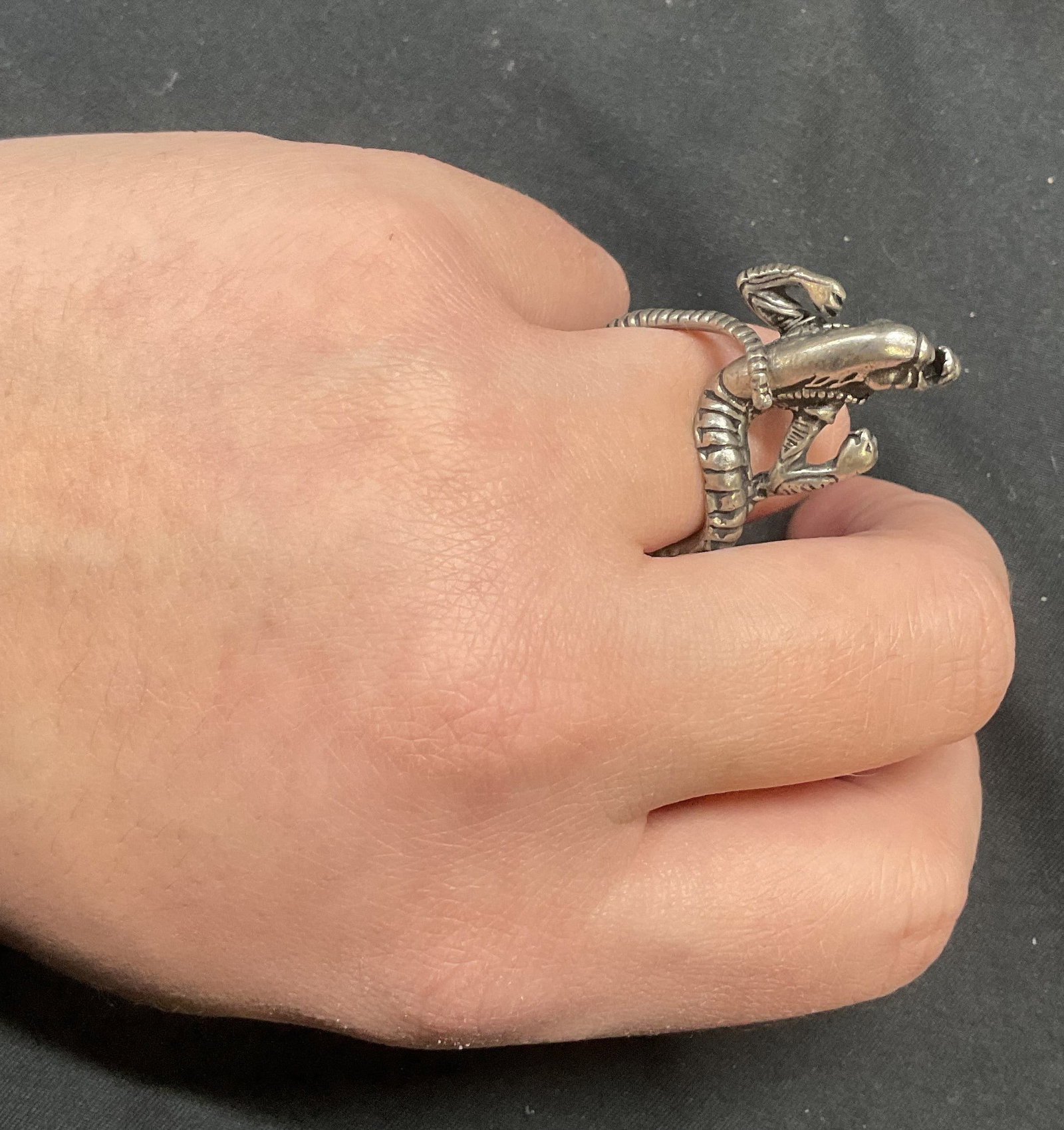 Silver Tone Alien Predator Ring: Silver tone Alien Predator motif ring. Raised alien with etched detail. Ring size 7. Some surface wear including scratching observed. Jewelry, estate jewelry, costume jewelry, cocktail jewelry, fashio