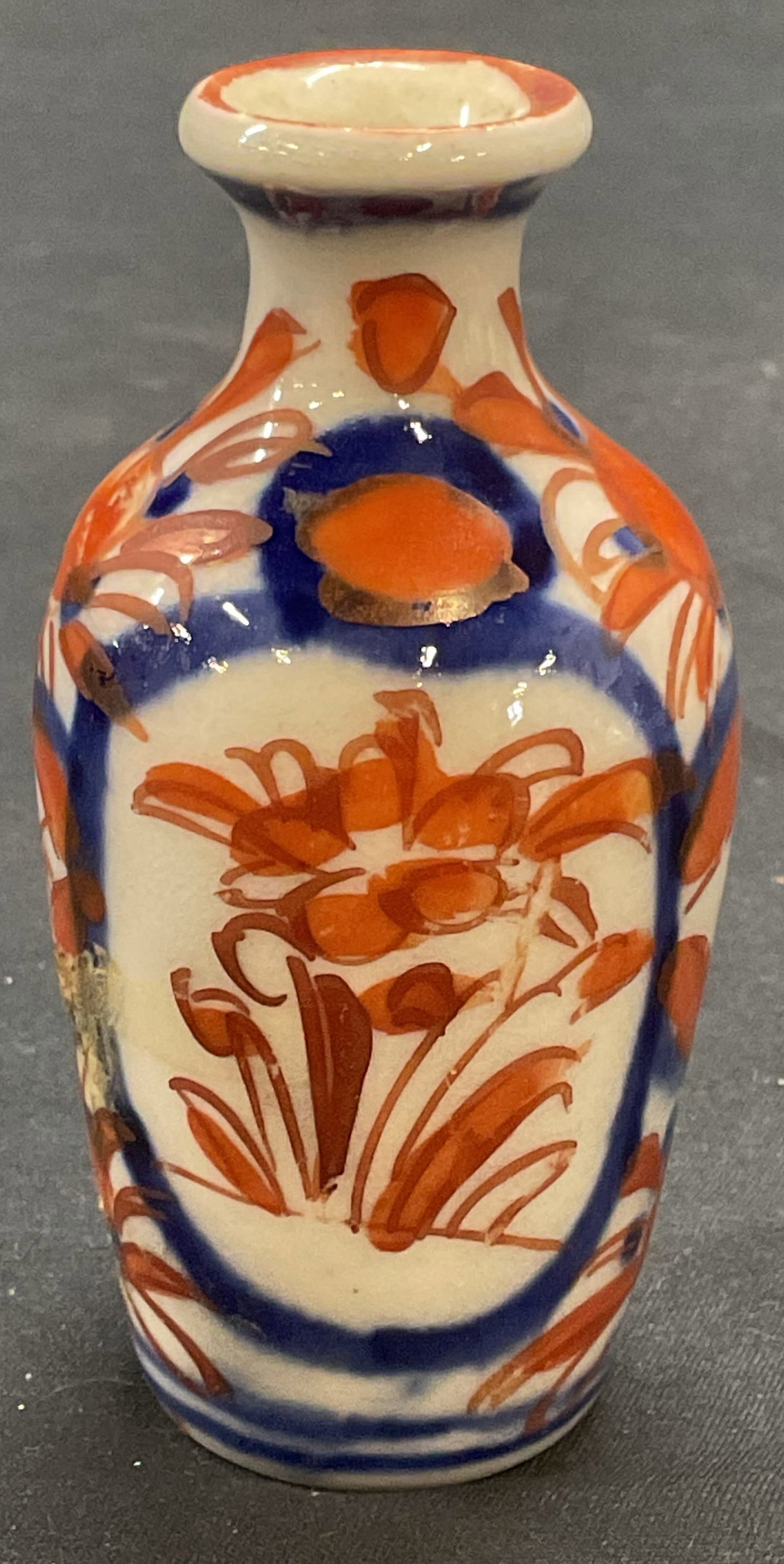 Antique Japanese Imari Porcelain Bud Vase: Antique Japanese Imari porcelain Bud vase. Blue and red with floral motif. Hand painted. Measures approx. 1.5 x 3.75 inches. Some surface wear including scratching and some loss to paint observed. Ima