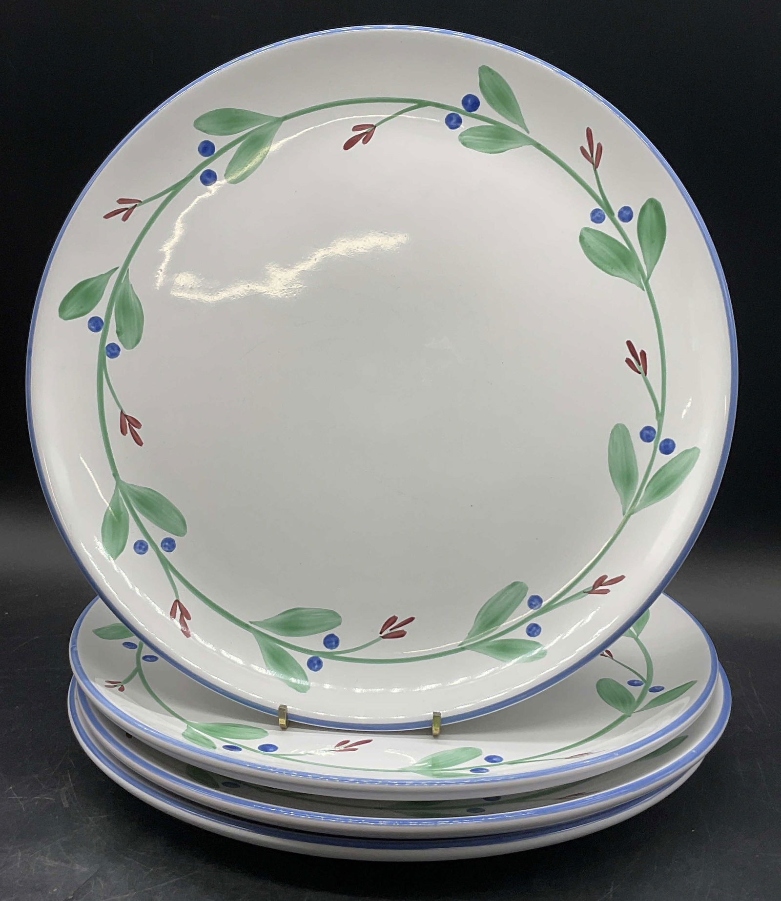 DANSK Berry Vine Motif Pottery Dinner Plates: Dansk berry vine motif pottery dinner plates. White, green, blue, and red hues. Undersides signed DANSK. Measures approx. 12L x 2W in. Crazing, discoloration, and surface wear present. Residue present