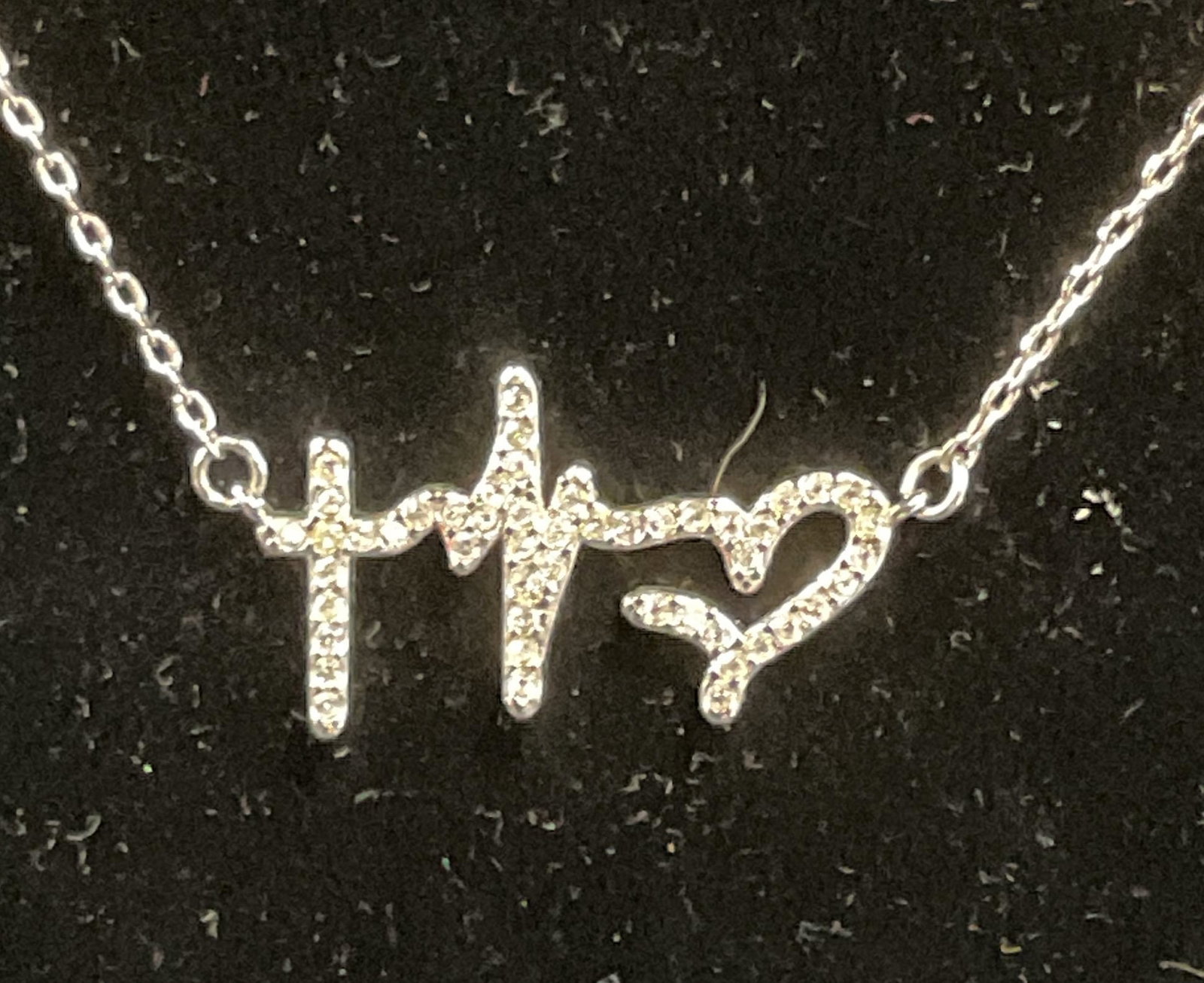 Swarovski Touchstone Crystal Heartbeat Necklace: Touchstone by Swarovski silver tone pendant necklace with heartbeat motif pendant Swarovski crystal decoration. Drop length approx. 9 inches. Signed on hang tag. Some surface wear including scratching