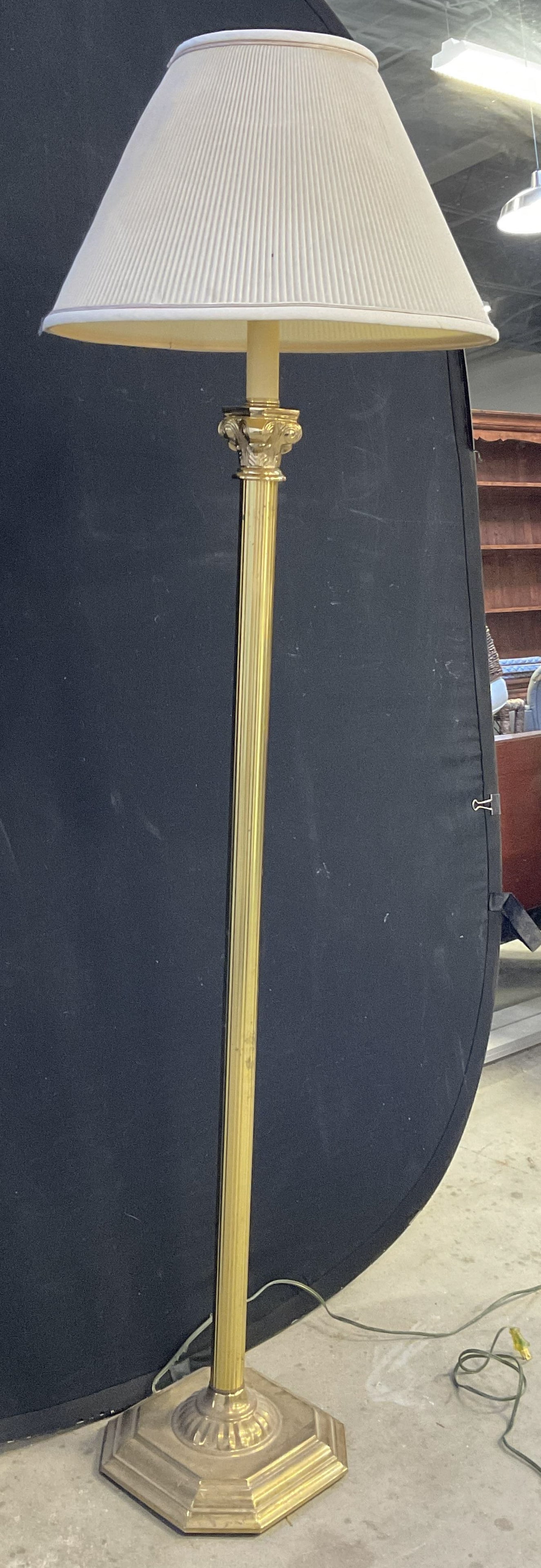 Brass Toned Metal Column Floor Lamp W/ Shade: A brass toned metal column floor lamp. Cones with a lampshade. Corded. Measures approx. 59H x 10W x 10D in. Width and depth measured at lamp base. Not tested for function. No finial to harp. Surface w